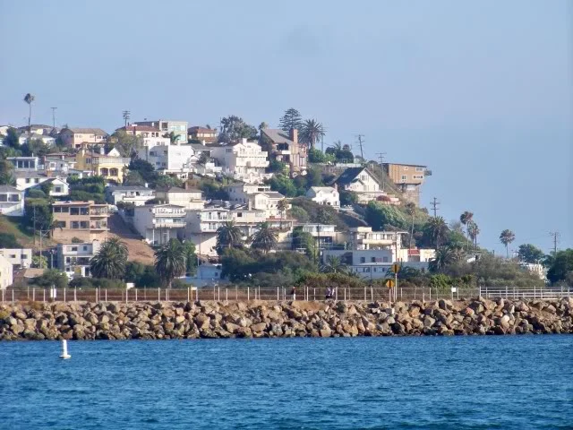 Playa Del Rey in the background over the jetty separating the marina inlet from Ballona Creek, Playa Del Rey is a community of Los Angeles, the name translates to Beach of the King