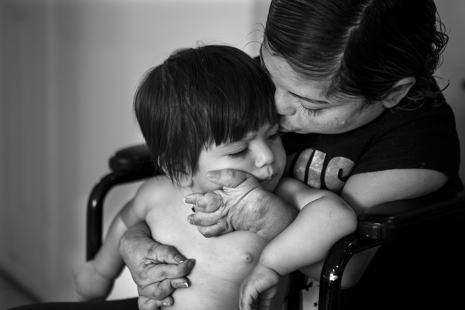  Rosa Caceres kisses her daughter Daniela Figueroa, 11 months, at their home in Lake Worth. Rosa has debilitating rheumatoid arthritis which forces her to use a wheelchair. Sometimes the pain in her joints is so bad that Rosa cannot even feed herself