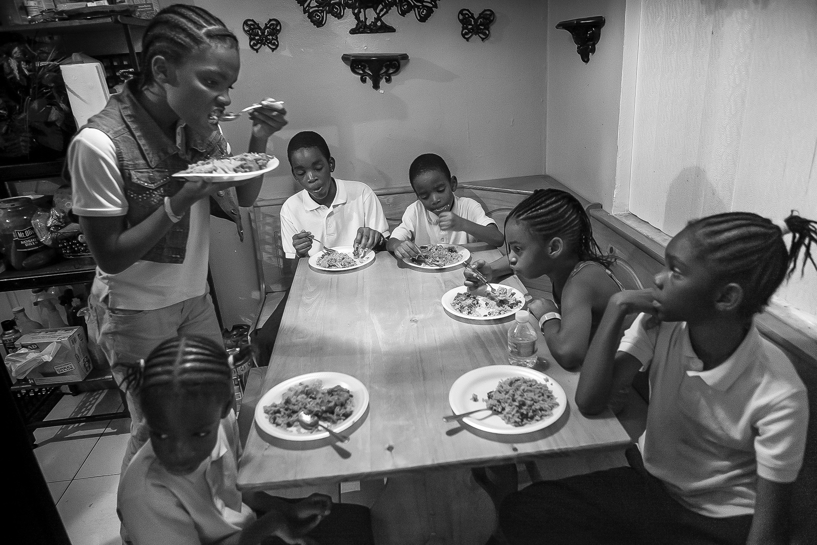  Part of the Fitzgerald family, left to right,&nbsp;Jernyah, Jermiah, Jermaine, Keyshawn, their cousin Joanna Fitzgerald and Jerqueriria squeeze around their grandmother Joann's kitchen table for dinner. Joann adopted six of her grandchildren and is 