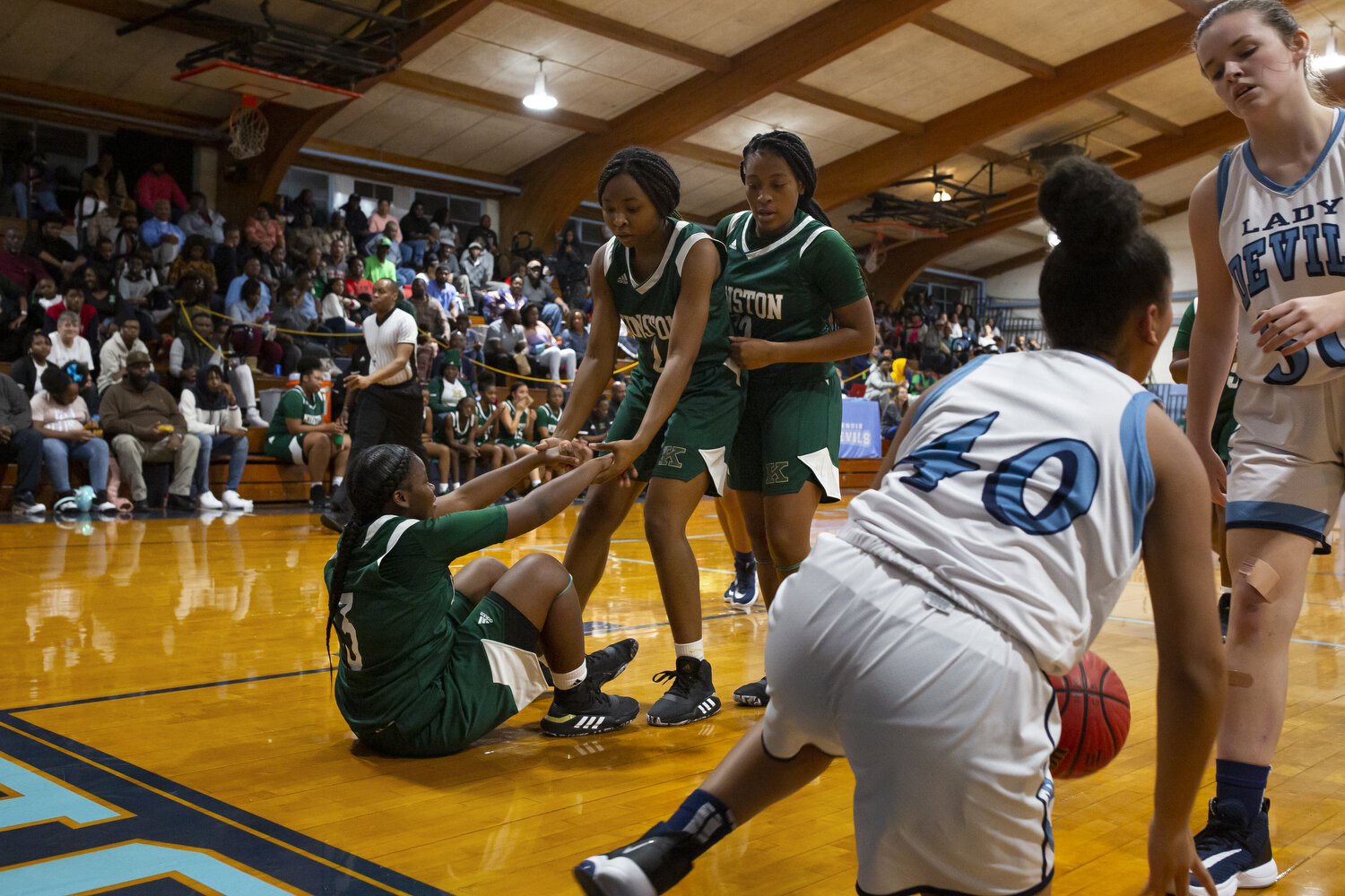  (Left to right) Sheriece Jones is helped up from the court by teammates Kahlia Hargett and Quiaira Powell during a game at South Lenoir High School. 