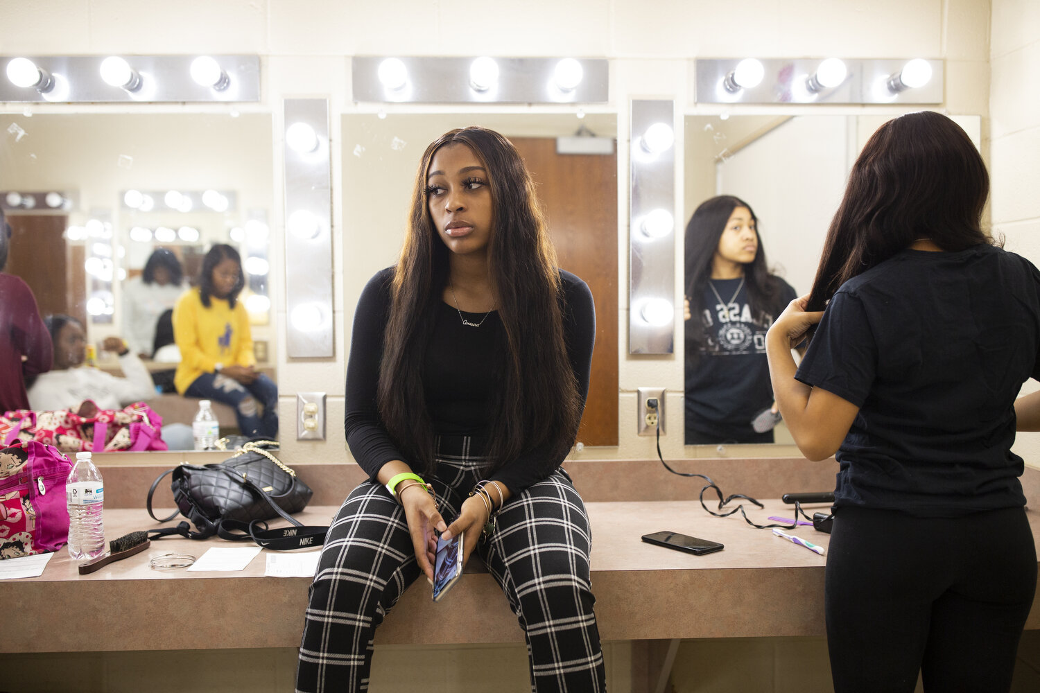  Senior Quiaira Powell watches her friends get ready to have their photos taken wearing caps and gowns a few months before graduation. Schools throughout North Carolina closed in March as a result of the coronavirus and a modified graduation ceremony