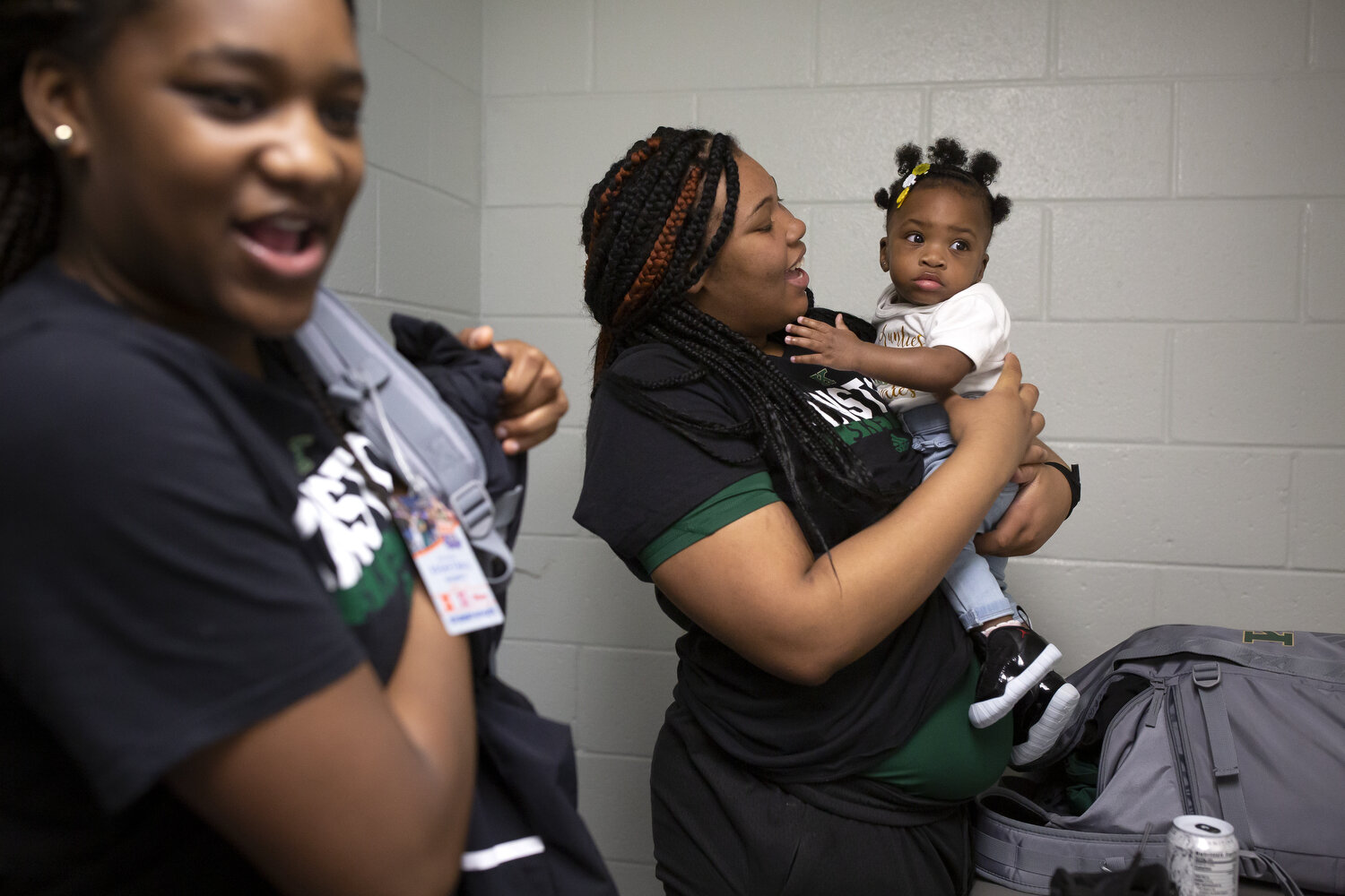  Anzaryia Cobb, center, holds her niece, right, while she and Winter Lane, left, prepare to leave the locker room following the team's loss in the Regional Championship game. The round of regional championship games were the last games to be played b