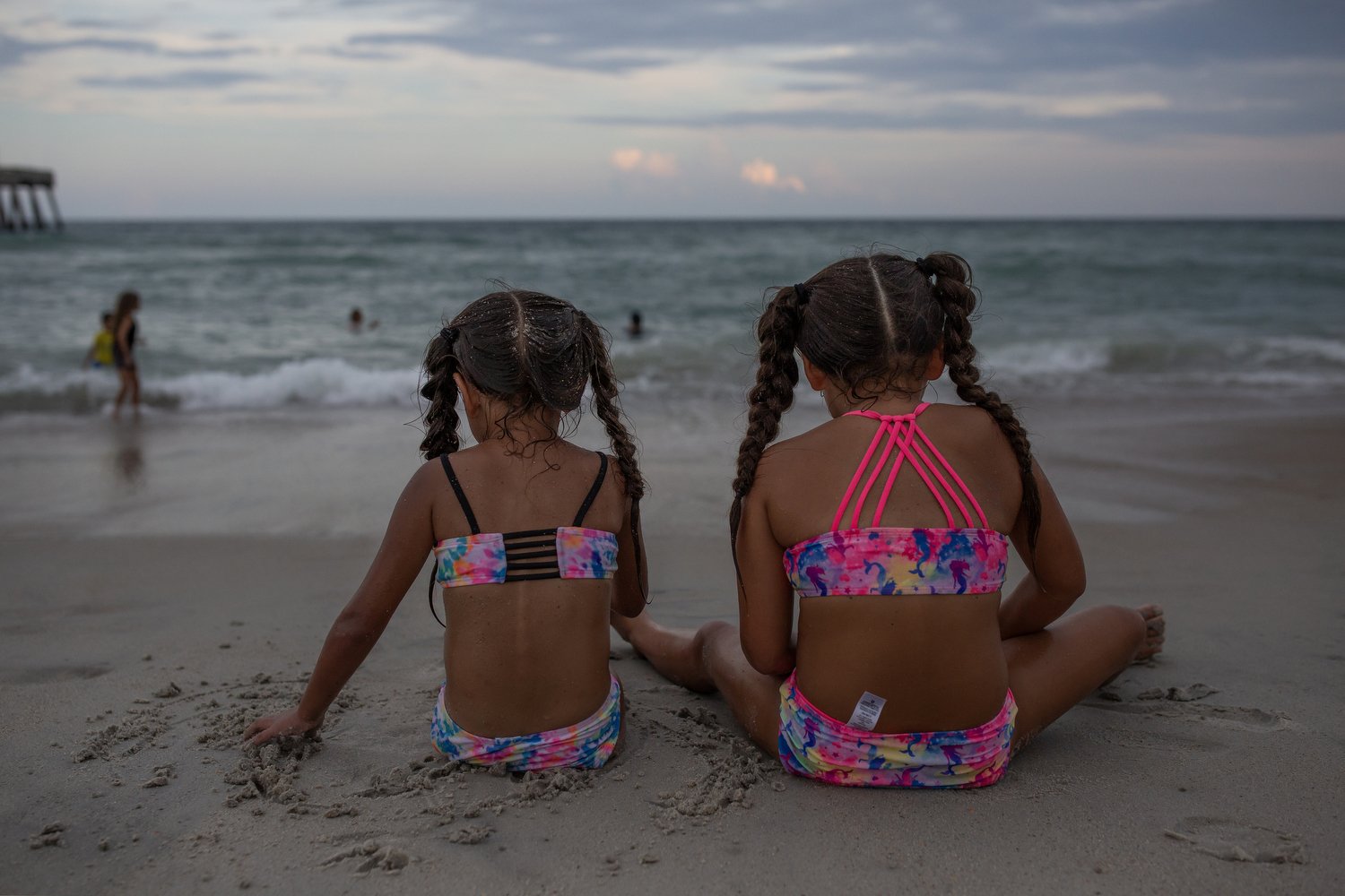  Gianna Olea, 5, left, and Katie Olea, 6, right, sit in the sand at Wrightsville Beach, North Carolina. Their mom Francisca Castro explained that the family all agreed that it was too hot to come to the beach in the middle of the day and preferred to