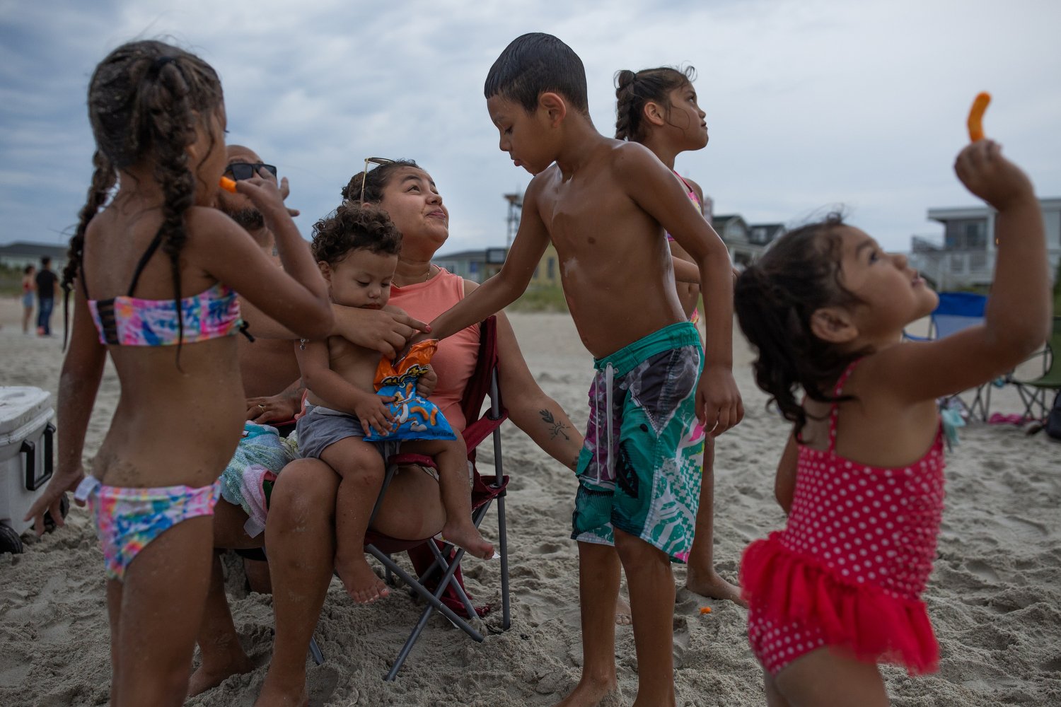  (Left to right) Gianna Olea, 5, Sergio Olea, Kayla Olea, 1, Francisca Castro, Sergio Olea Jr., 8, Katie Olea, 6, and Sherlyn Olea, 3, feed the seagulls snacks at the beach as the sun goes down at Wrightsville Beach, North Carolina.   For The Washing