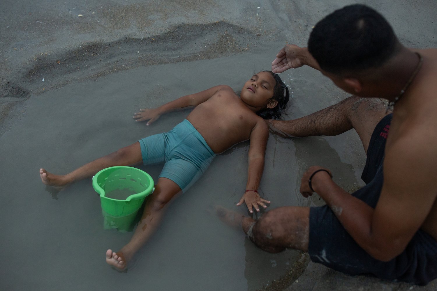  Camila Gonzales, 3, left, lays in the water with her dad Jonathan Gonzales, right, at Wrightsville Beach, North Carolina. Gonzales explains that he prefers to come to the beach in the evenings when it’s cooler because his daughter is outside a lot p