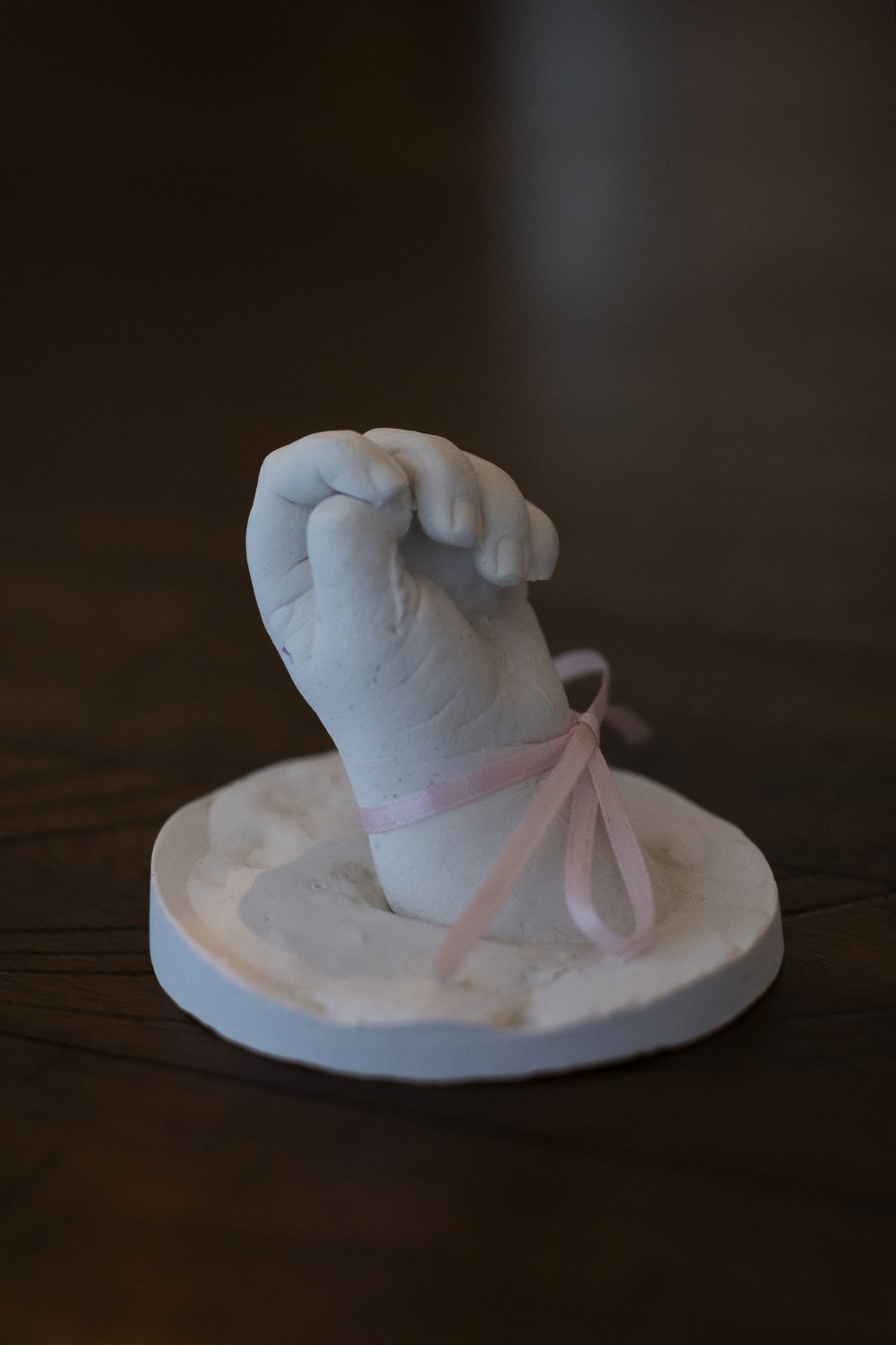  A cast of Lacy Ann Laughinghouse’s hand sits on the table of her half sister Ellie Crout in Wilson, North Carolina. Lacy Ann died at the age of four weeks old and her death was perhaps in part the catalyst for the deaths of three more family members