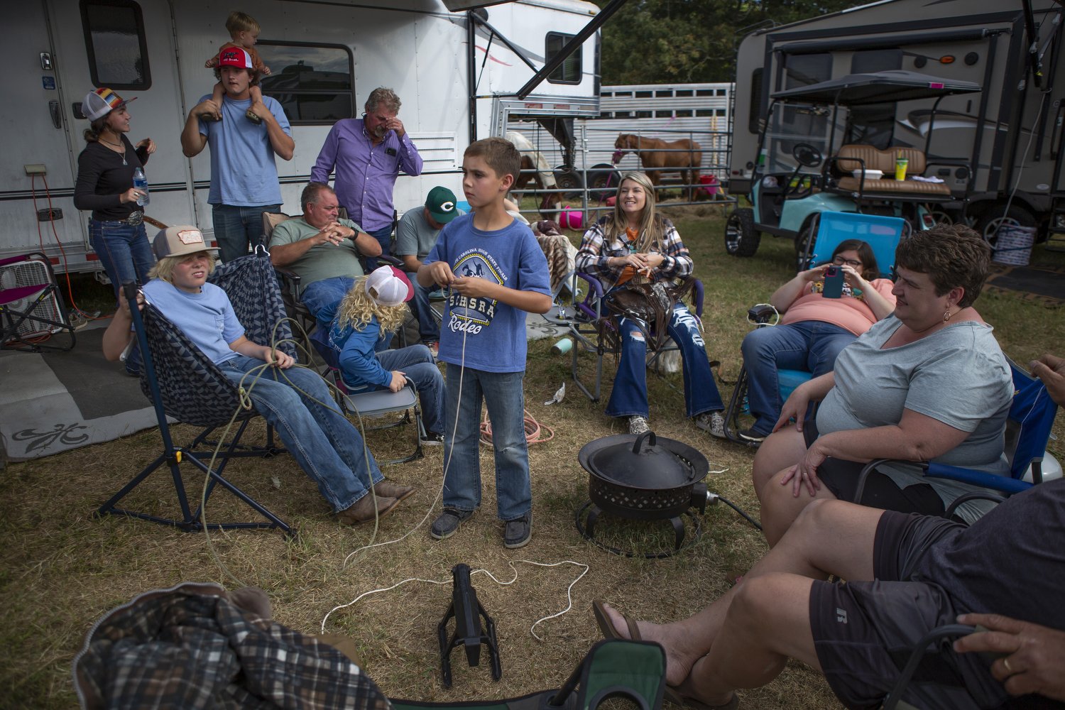  Surrounded by family Dale Durden, center, practices roping a tiny toy calf during Mule Days in Benson, North Carolina.  For Cardinal &amp; Pine 