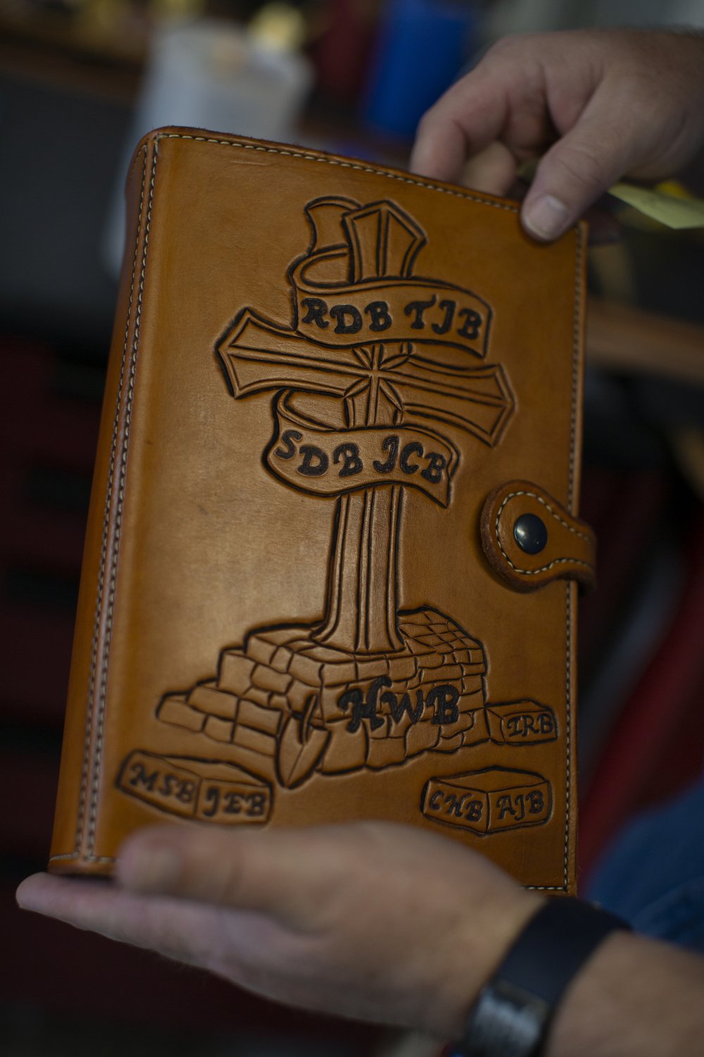  Michael Schneider, a retired Marine Corps Master Sergeant, holds a leather Bible cover he made in his garage studio at his home in Swansboro, North Carolina. He uses art and music therapy to help manage his epilepsy and PTSD following a traumatic br