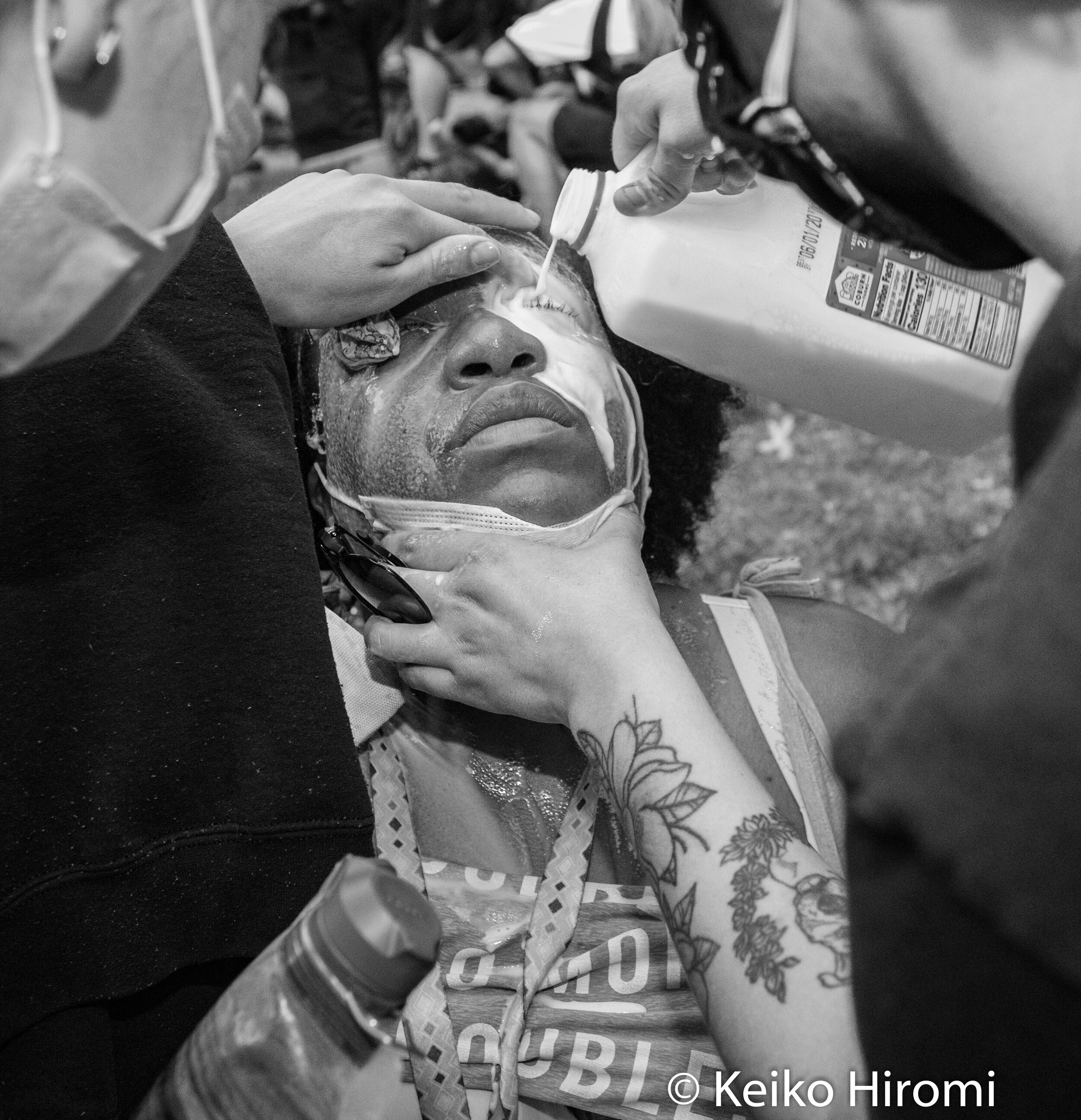  May 29, 2020, Boston, Massachusetts, USA: Protesters pouring milk to a women who was pepper sprayed in front of Boston Police D-4 station during a protest in response to deaths of George Floyd and against police brutality and racism at Peter's park 