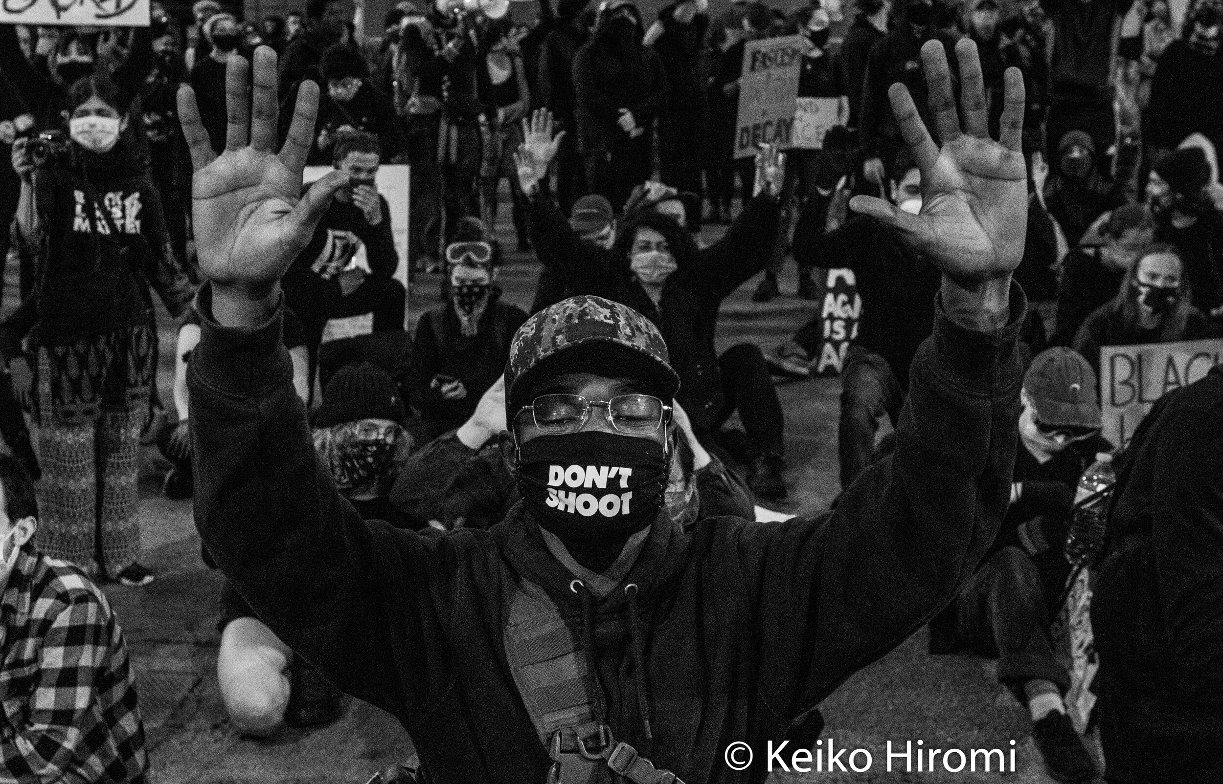  June 7, 2020, Boston, Massachusetts, USA: A protester, wearing a face mask "Don't shoot" kneels hands up during a rally in response to deaths of George Floyd and against police brutality and racism  in Boston. 