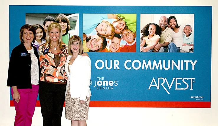 Unveiling of Arvest banner at The Jones Center Lisa Ray, President/CEO, and Branch Administrator, Julie Shook, both of Arvest Springdale together with Kelly Kemp-McLintock, Chief Advancement Officer of The Jones Center, proudly displayed their new banner located in the Northern alcove. Arvest's corporate support provides important operating support for The Jones Center and its programs.