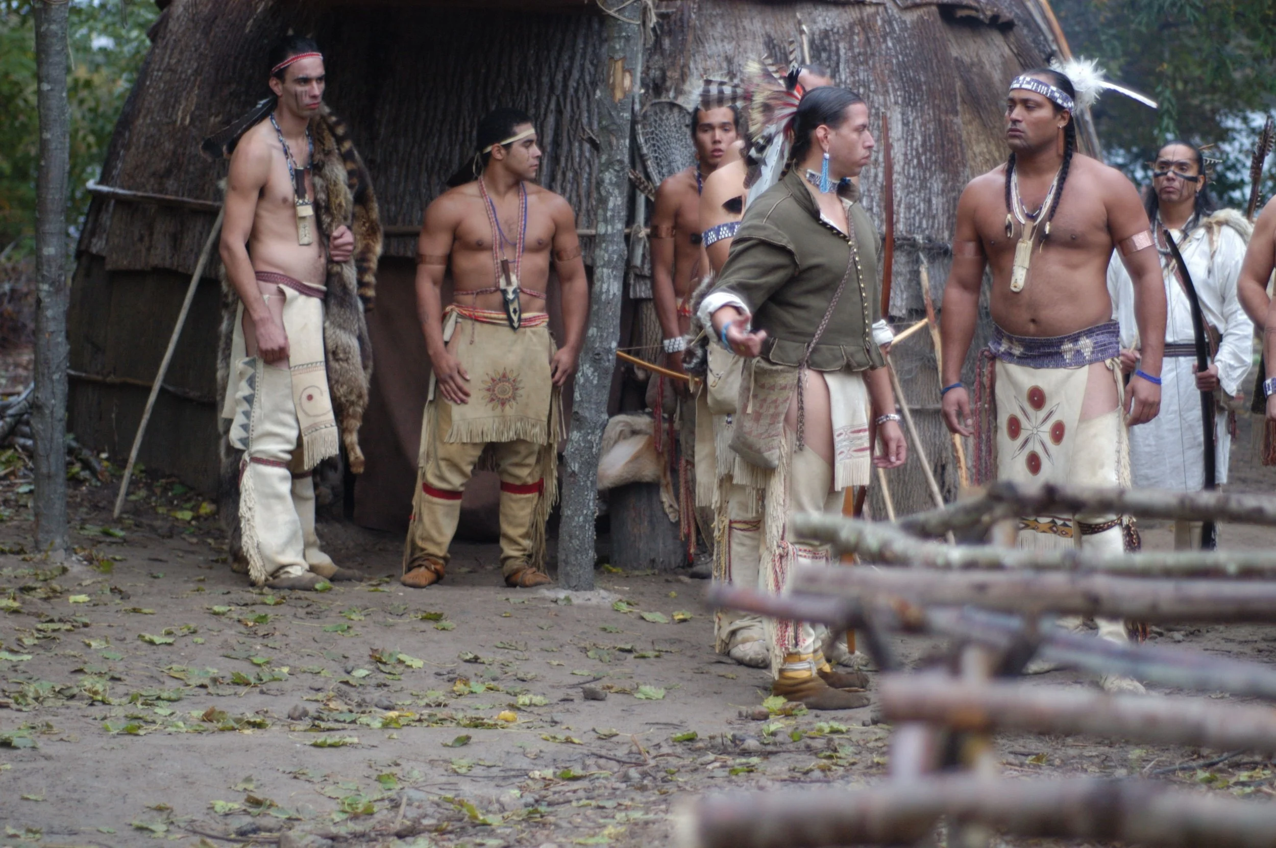 Wampanoag actor (Jonathan Perry, green shirt) portraying Tisquantum, speaking to Massasoit (played by Dave Weeden) in Desperate Crossing . Promotional image courtesy of Lone Wolf Documentary Group.