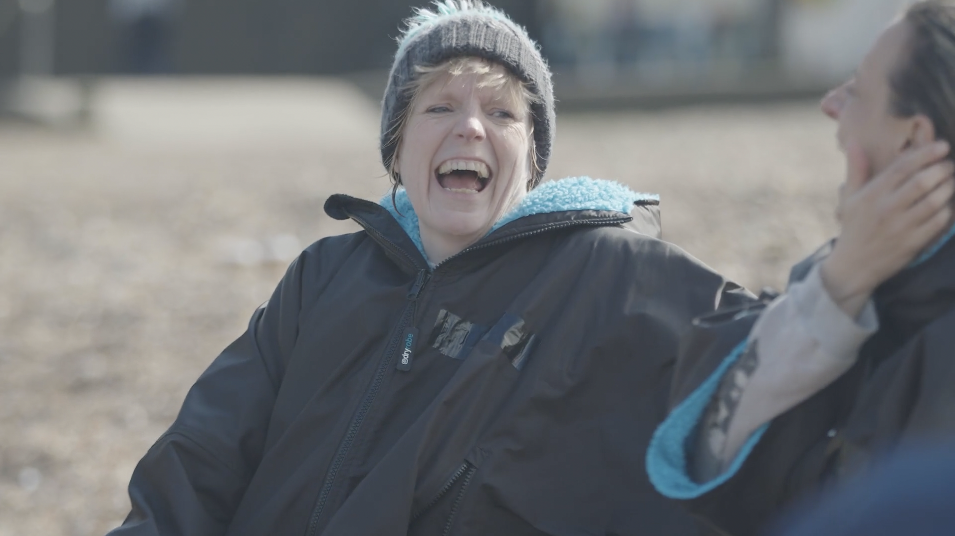 A woman laughs on the beach
