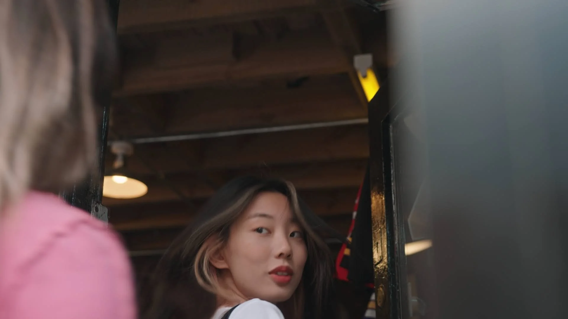 A girl walks through a shop door. 
