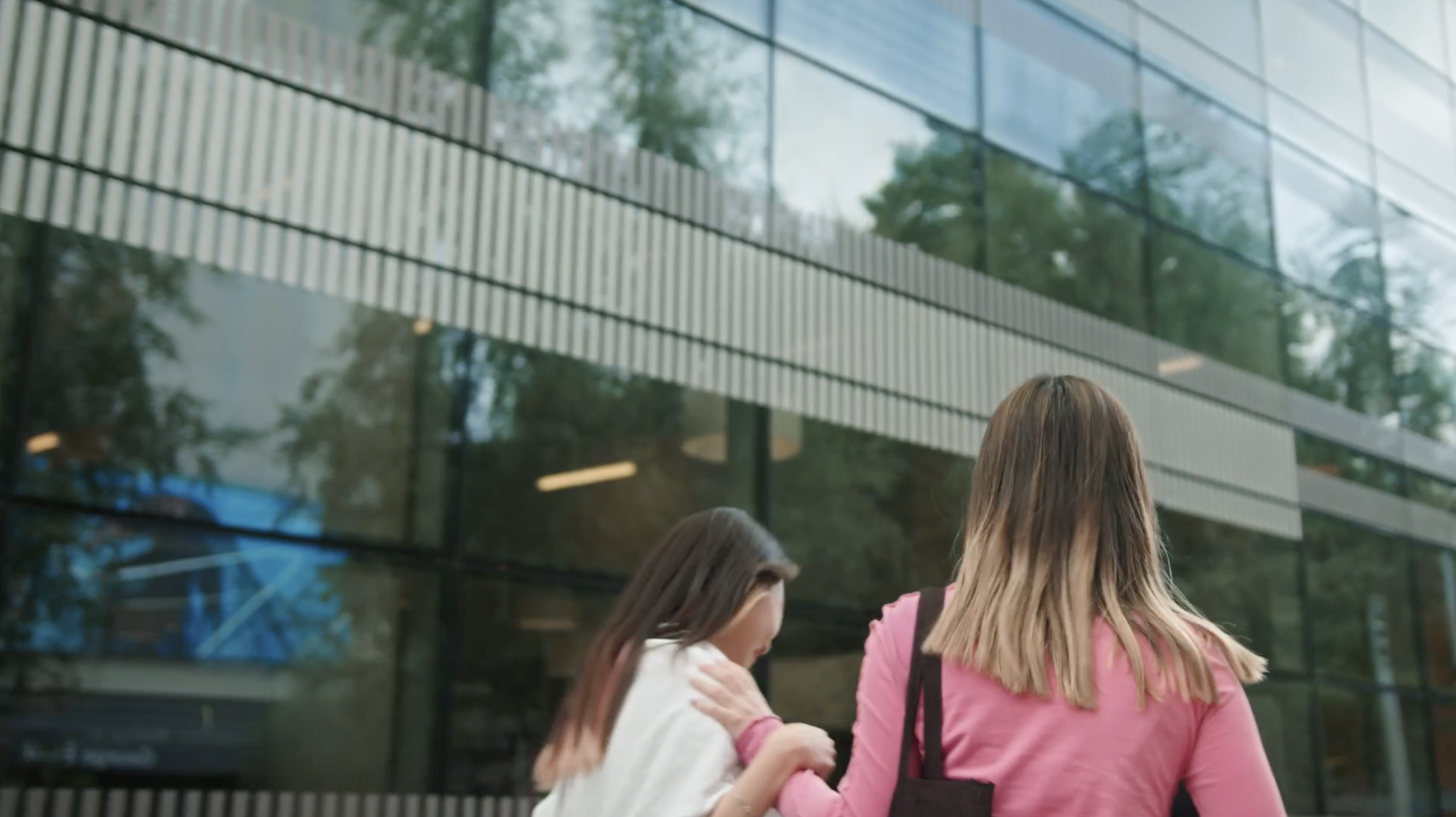Two girls walk in a uni campus