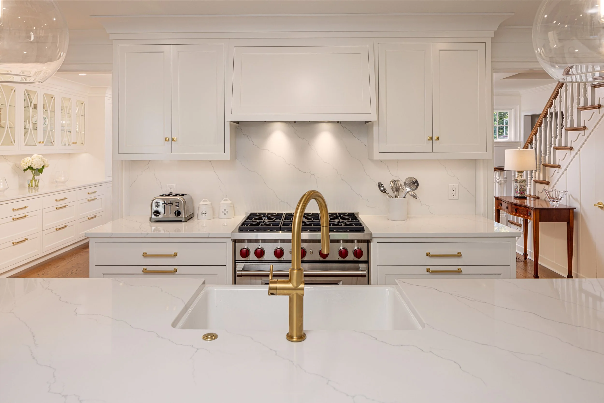   White finishes and gold fixtures make the whole space look pristine and modern.  