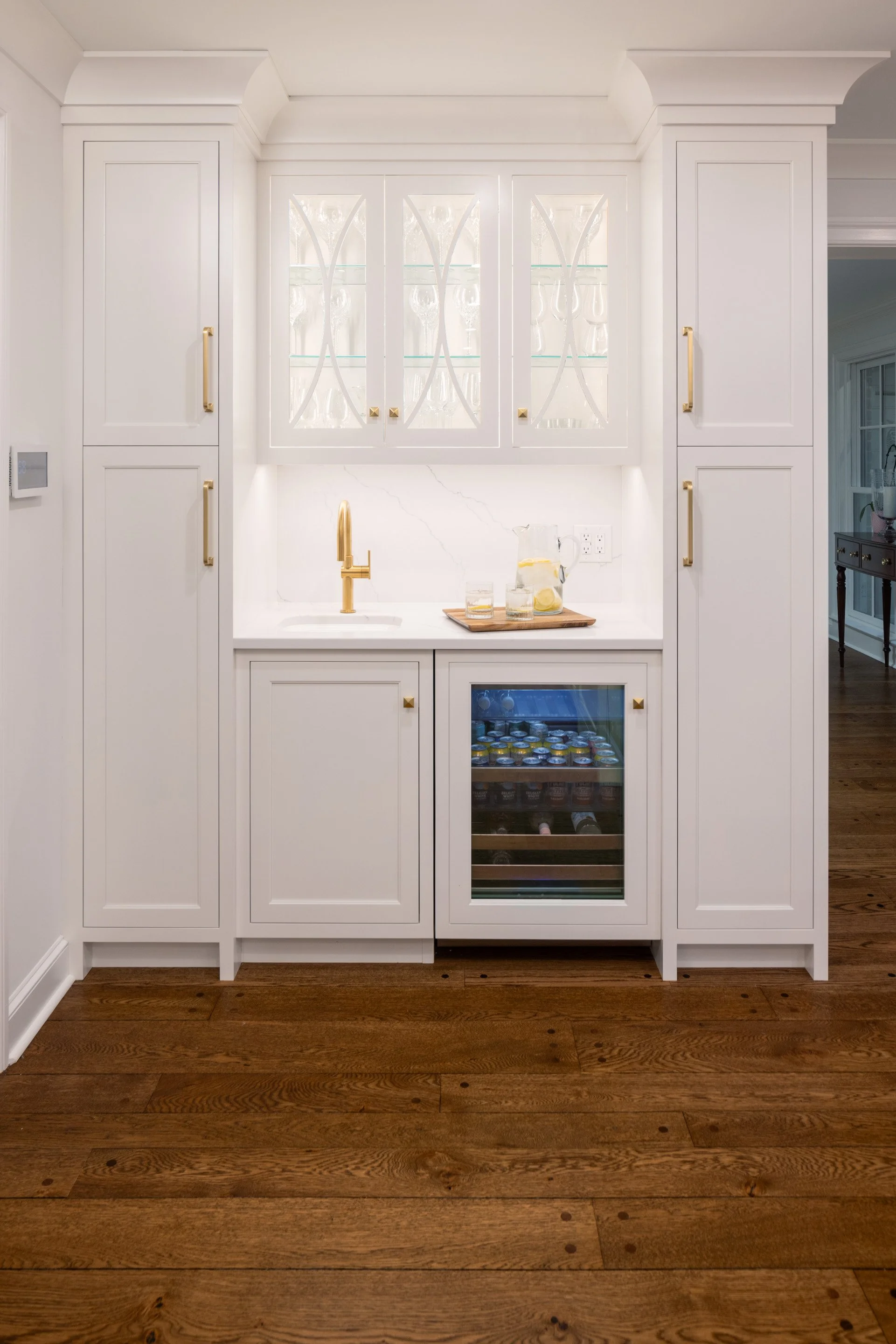  A second sink, a built-in wine cooler, and windowed glassware cabinets make this nook a perfect place for guests to serve themselves drinks.  