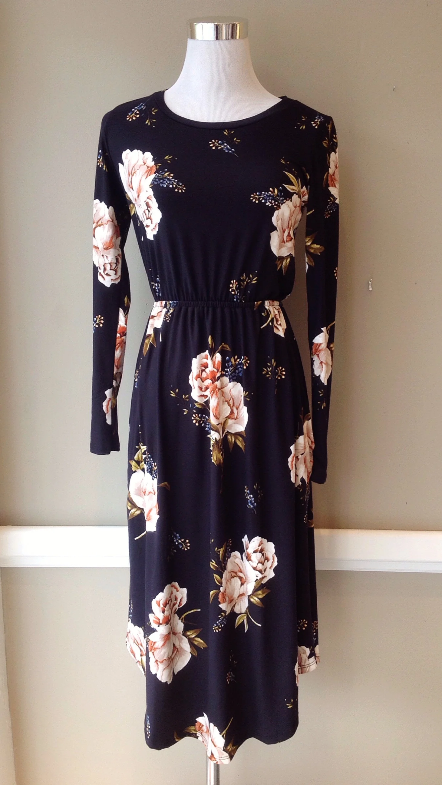 Long sleeve, soft knit dress with rounded hem and side seam pockets in black/pink floral, $38