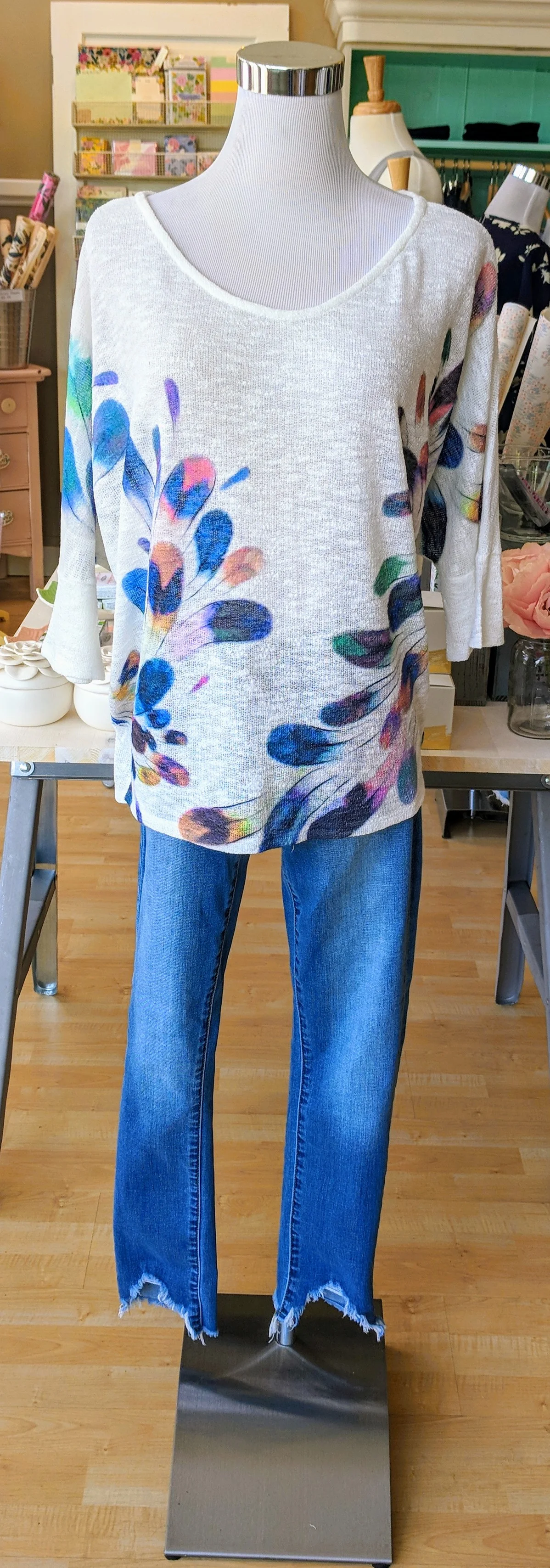 Ivory feather print top with scoop neckline. 