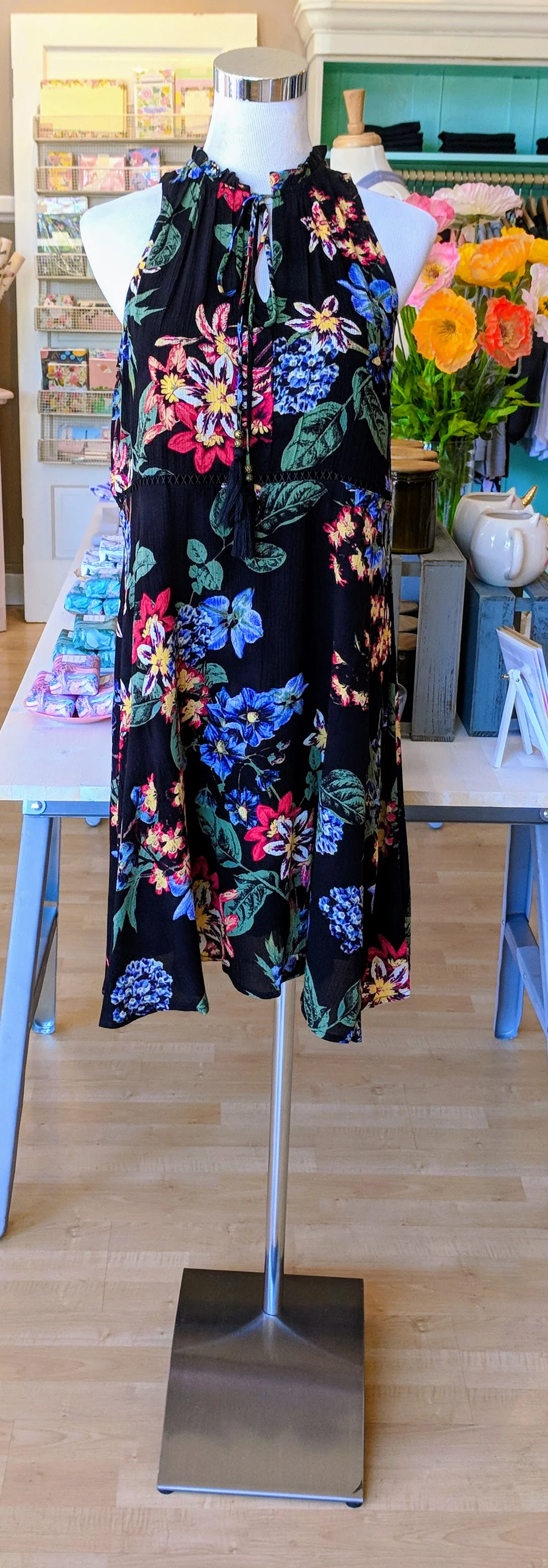 Black floral midi dress with embroidery detail on front and tassels. 