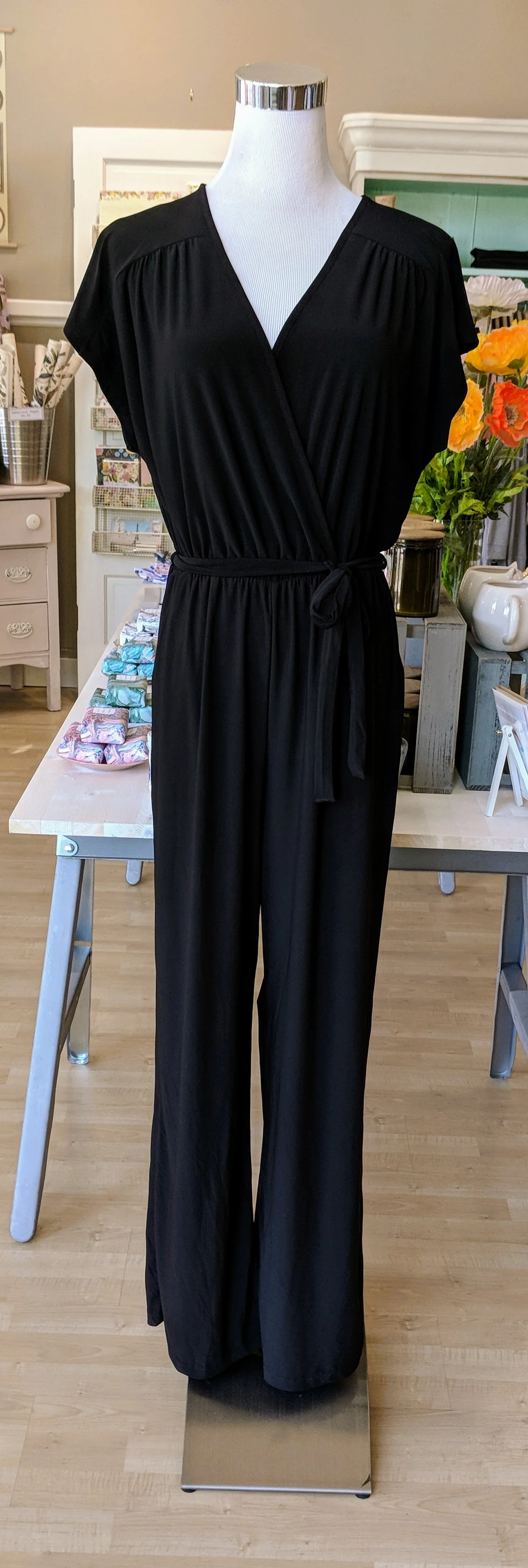 Black cap sleeve jumpsuit with tie belt. 