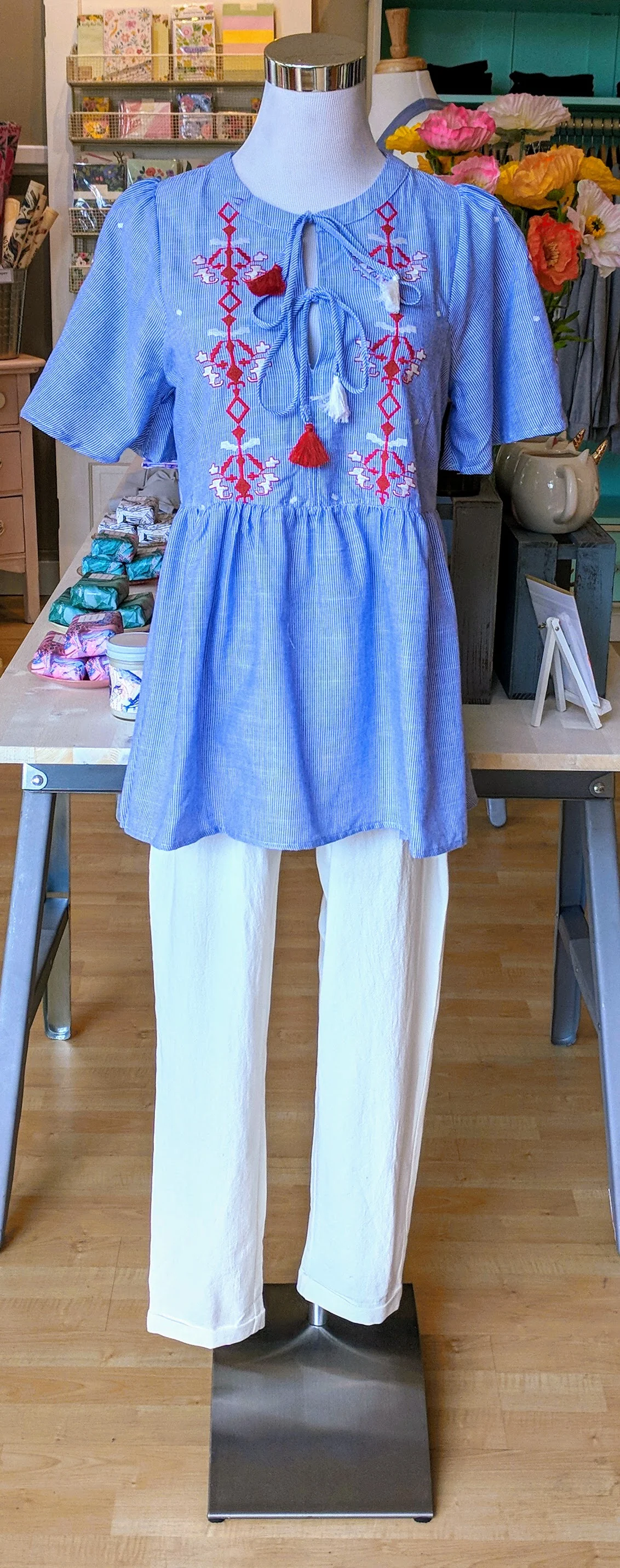 Blue and red embroidered baby doll top with tie detail on front. 