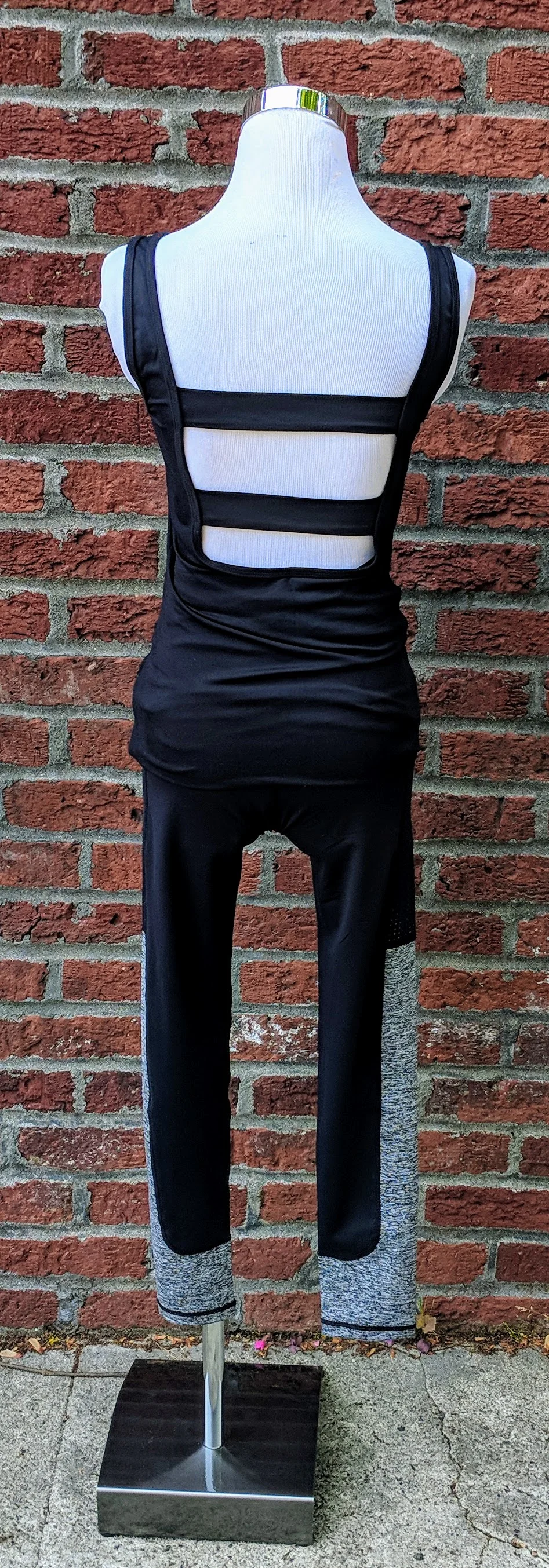 Black classic front tank with cut out panels on back featuring front zipper pocket.