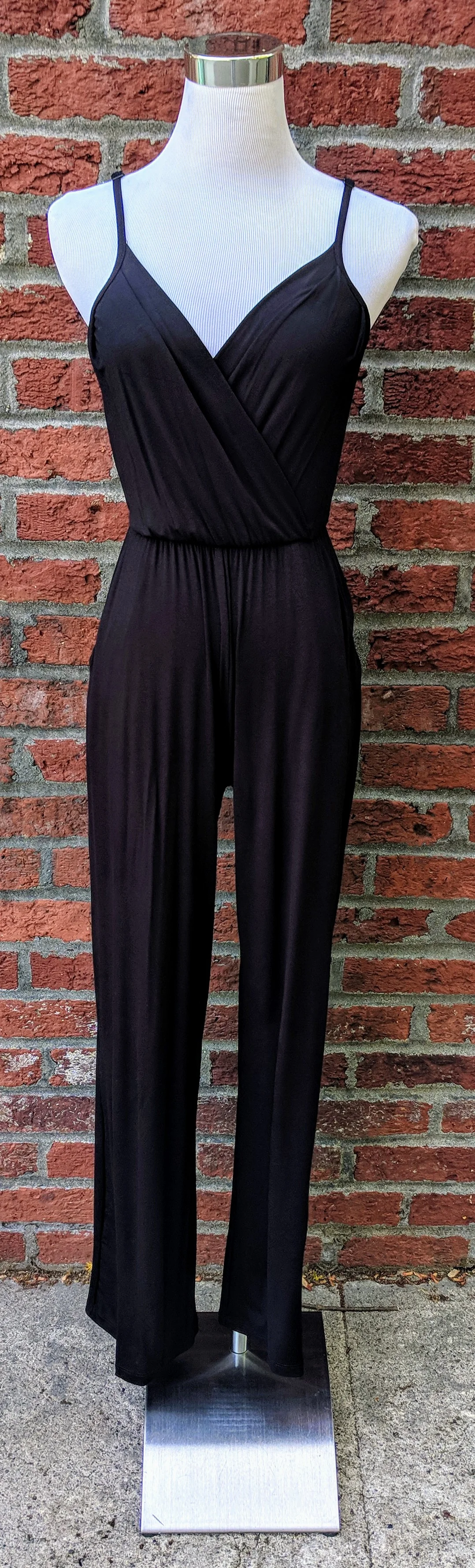 Black jumpsuit with overlapped v-neckline and pockets. 