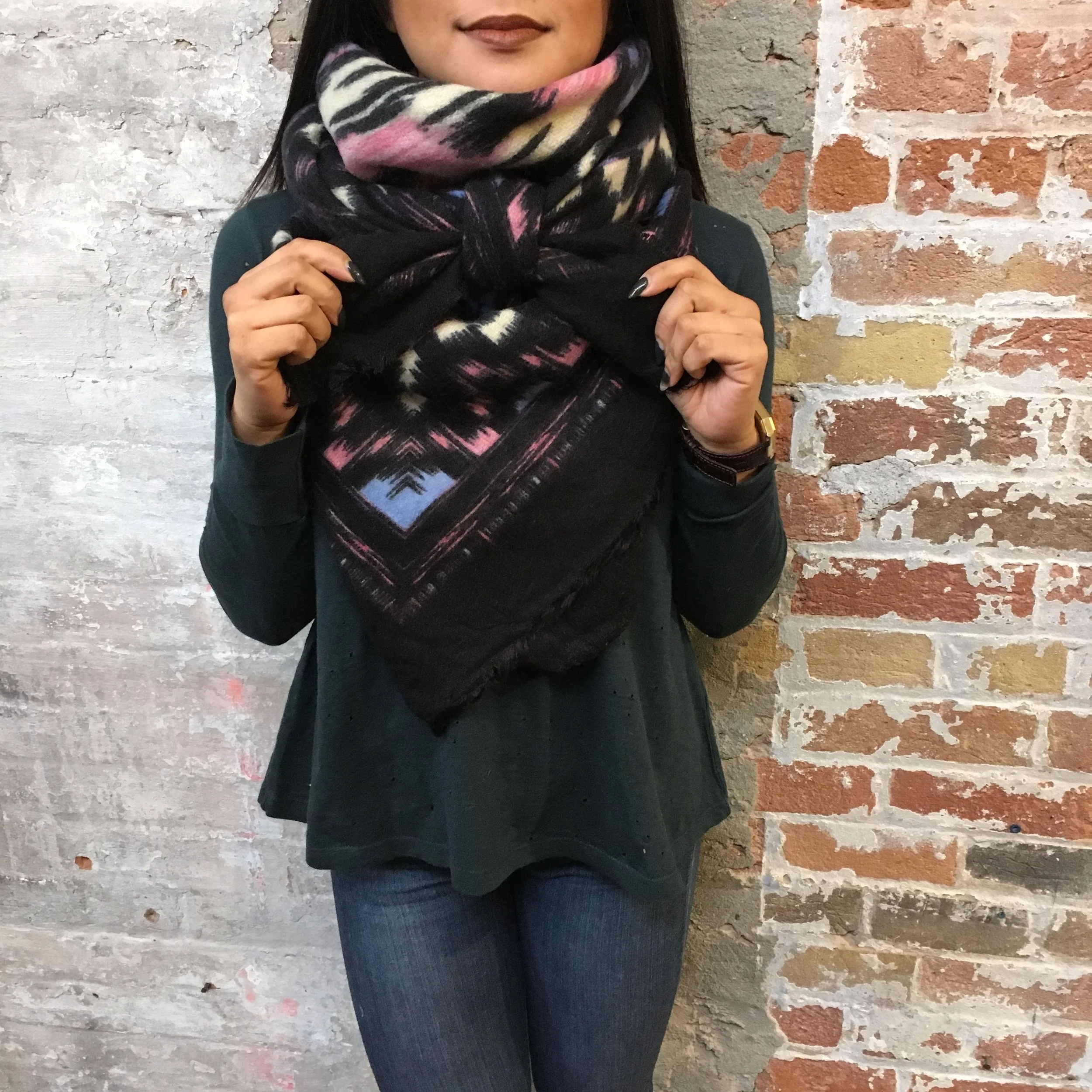  A variation of the one above - Gather two ends of the triangle over and around your neck, meeting the point hanging down the front of your body. This time, tie the two ends over the larger piece and and tie a knot, creating a beautiful bow.