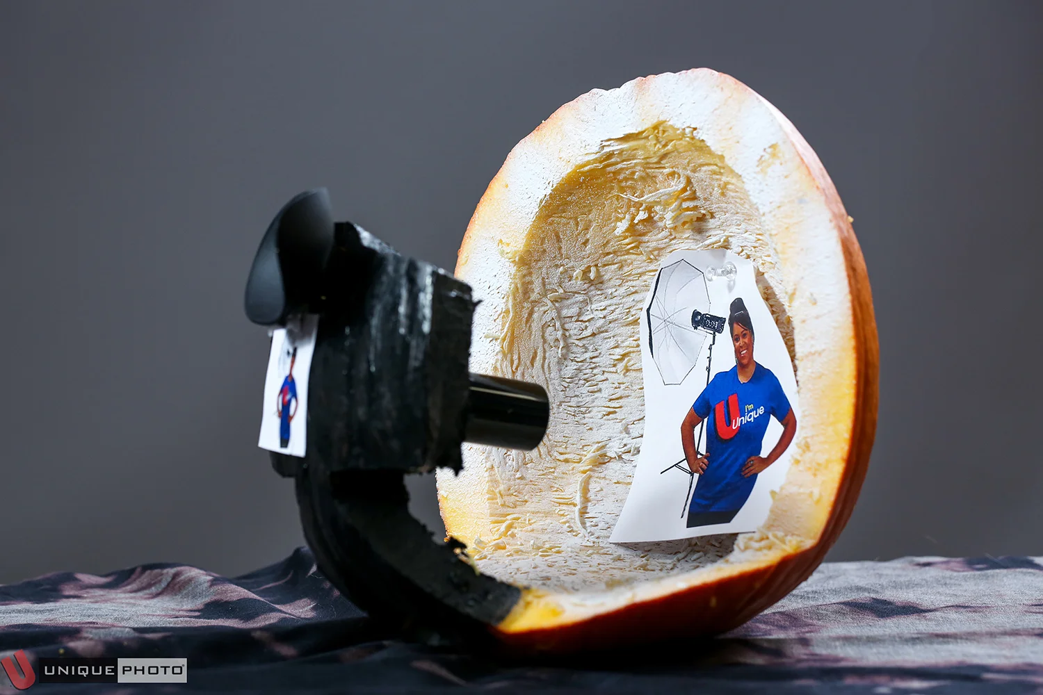 “20.3 MP(Megapumpkins) Mirrorless Analog Squash w/Optional Jayme V. Glamour Background” by Ryan Alexander. This pumpkin consists of a real, working eyecup, a pumpkin DSLR body, and an old film canister as a lens.
