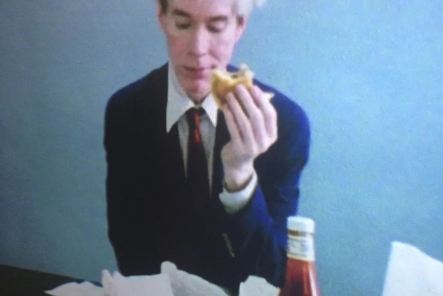 Video segment: Warhol eating a hamburger