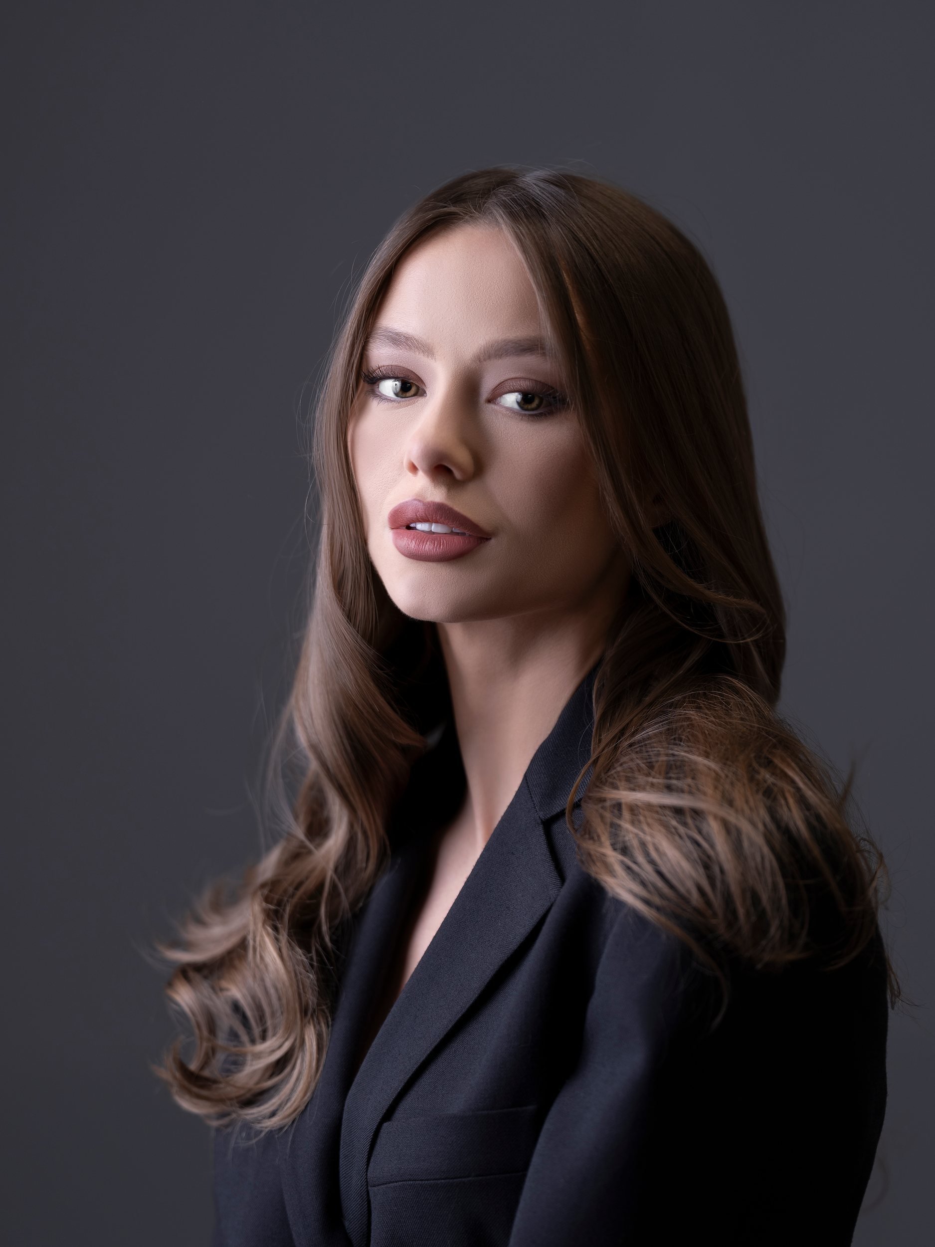 studio-headshot-woman-black-blazer-gray-backdrop.jpg