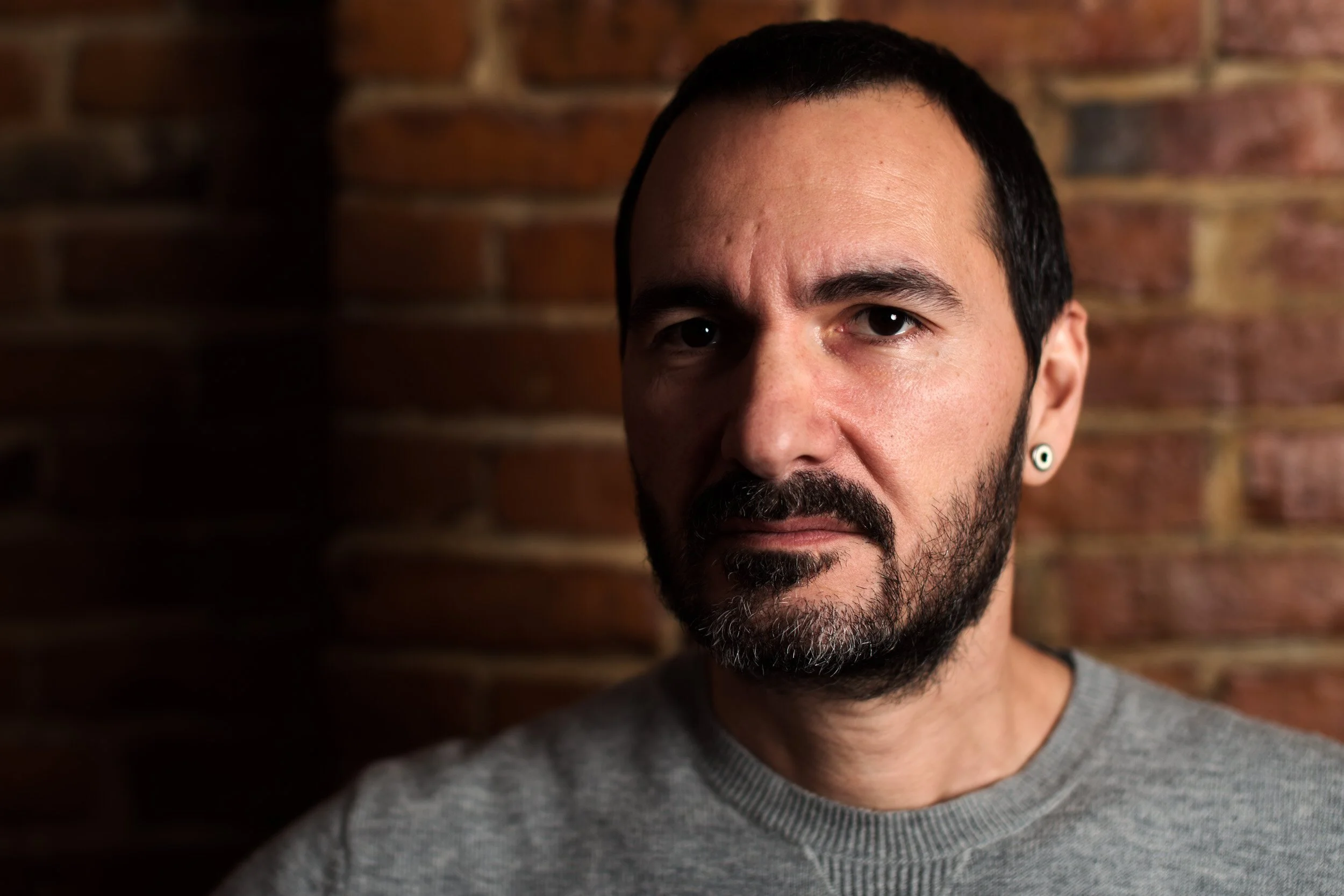 portrait-bearded-man-gray-sweater-brick-wall.jpg