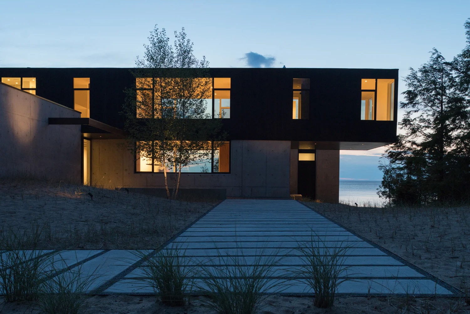 Modern lake house with cantilever at dusk — William Kaven Architecture