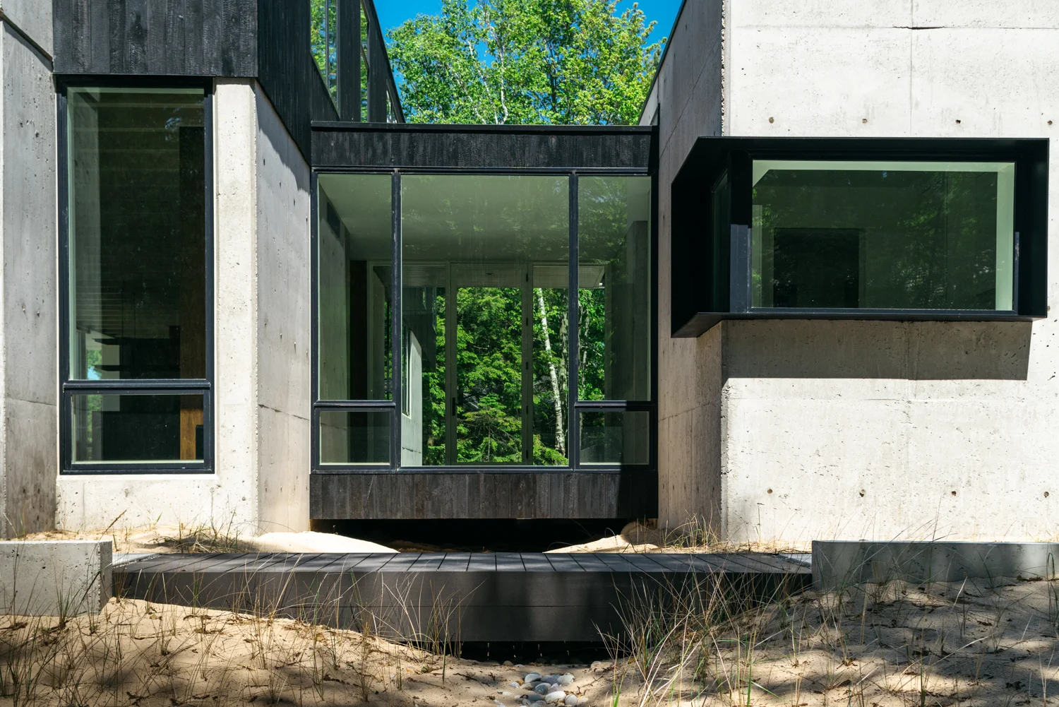 Bridge at modern lake house with shou sugi ban and board formed concrete exterior — William Kaven Architecture