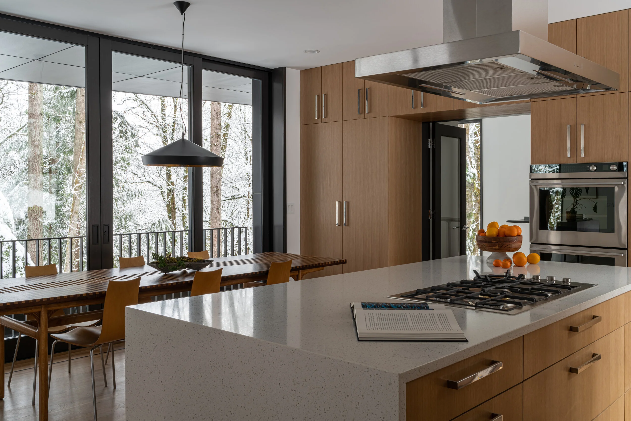 Modern dining room and kitchen in forest house — William Kaven Architecture