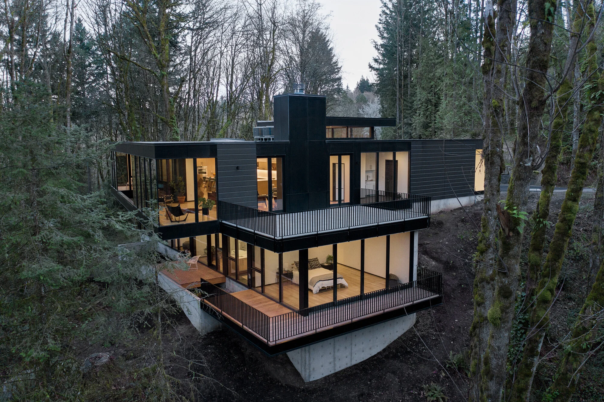Black house built into forest hillside — William Kaven Architecture
