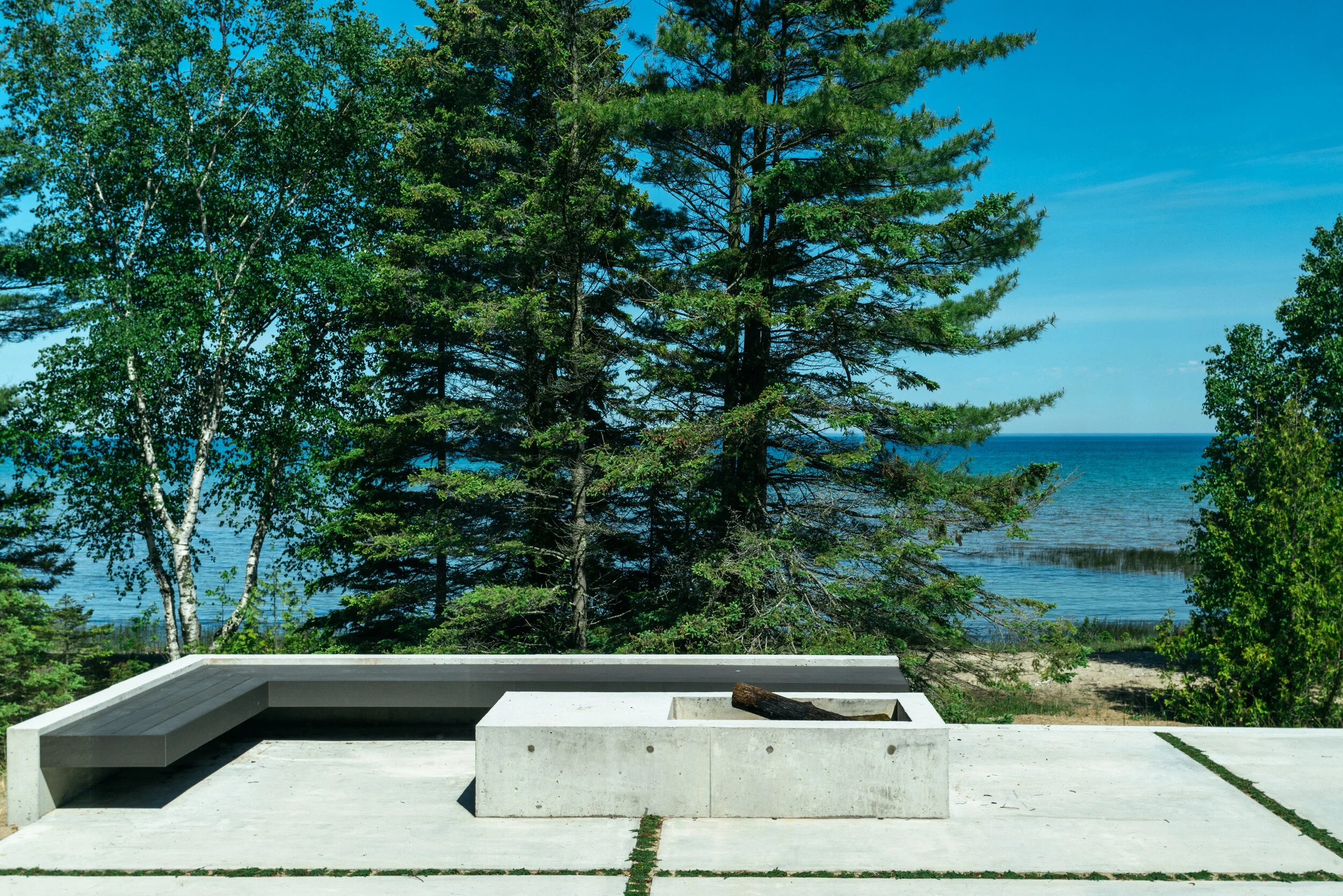 Terrace with firepit at modern lake house in Michigan — William Kaven Architecture