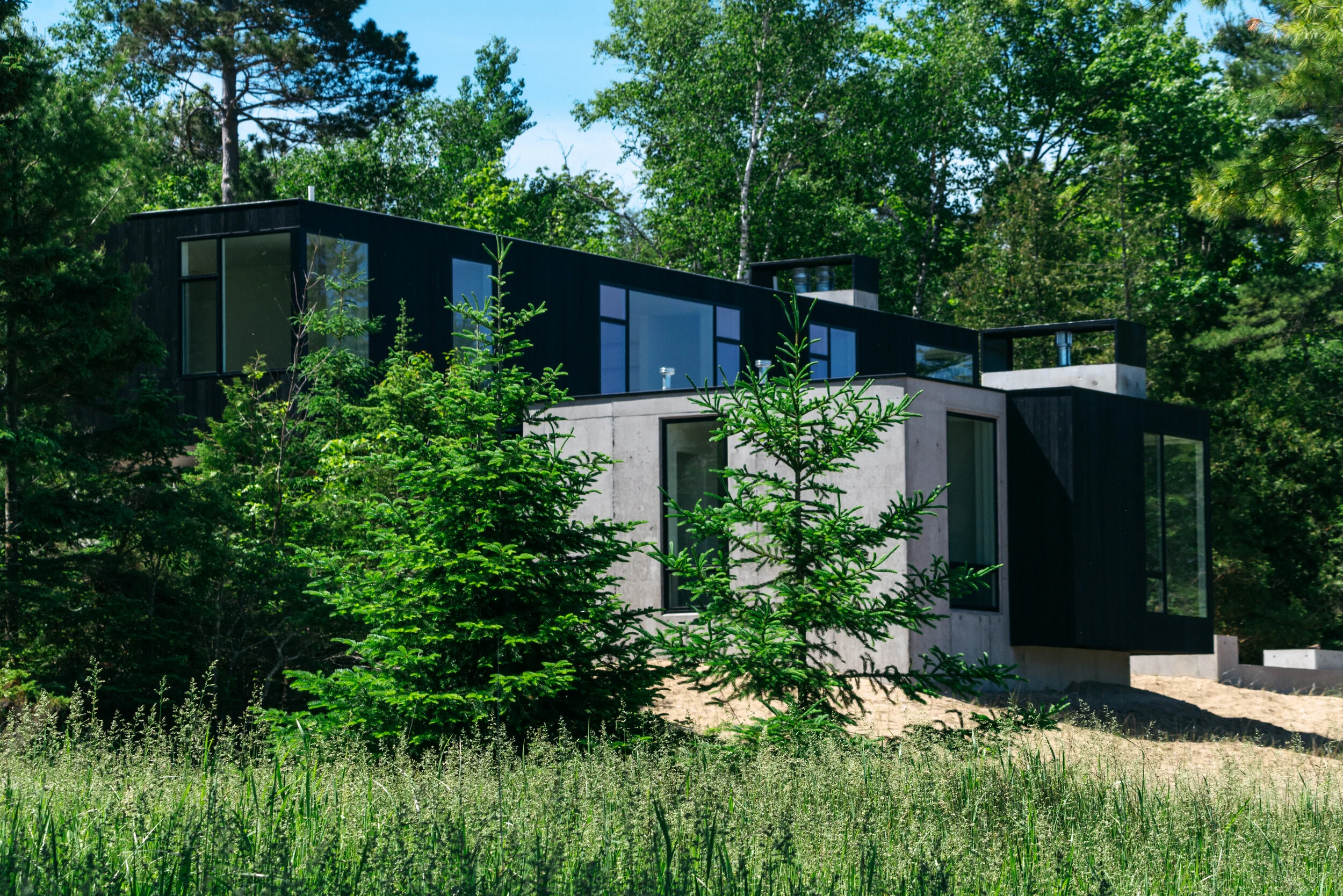 Modern lake house with trees — William Kaven Architecture
