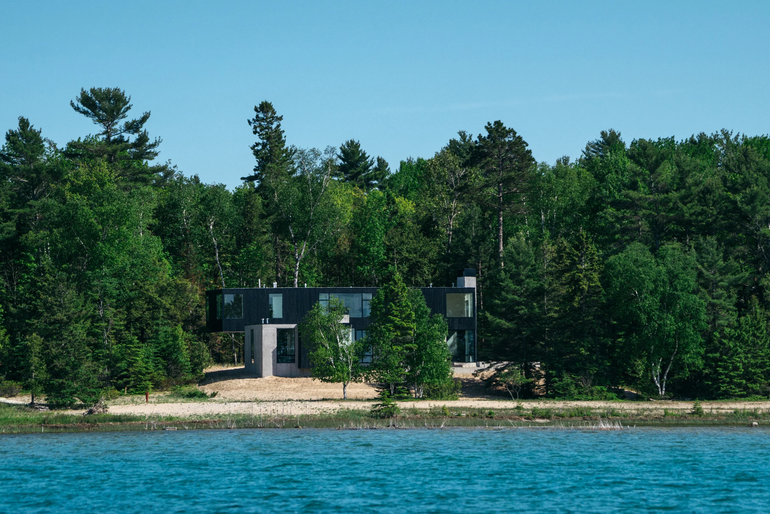 Modern house on Lake Michigan with dense trees — William Kaven Architecture