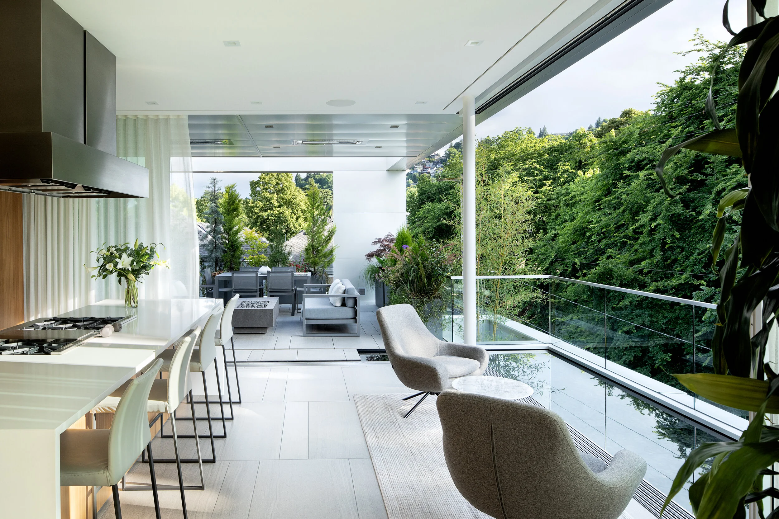 Modern kitchen open to rooftop terrace with reflecting pool — William Kaven Architecture