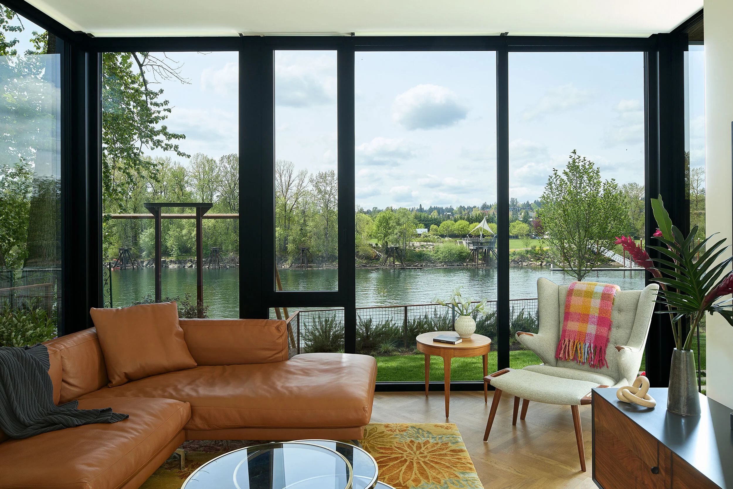 Family room with leather couch and view of river — William Kaven Architecture