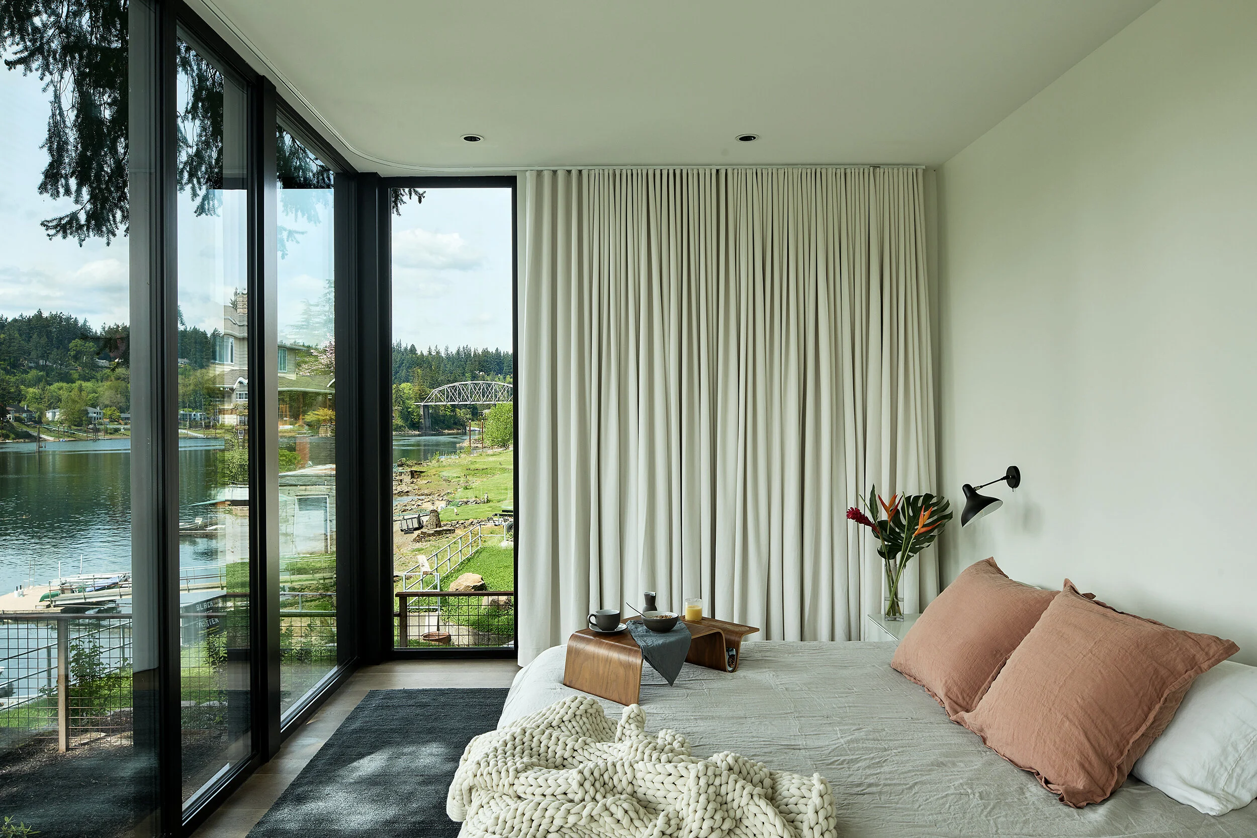 Primary bedroom with drapery and view of river — William Kaven Architecture