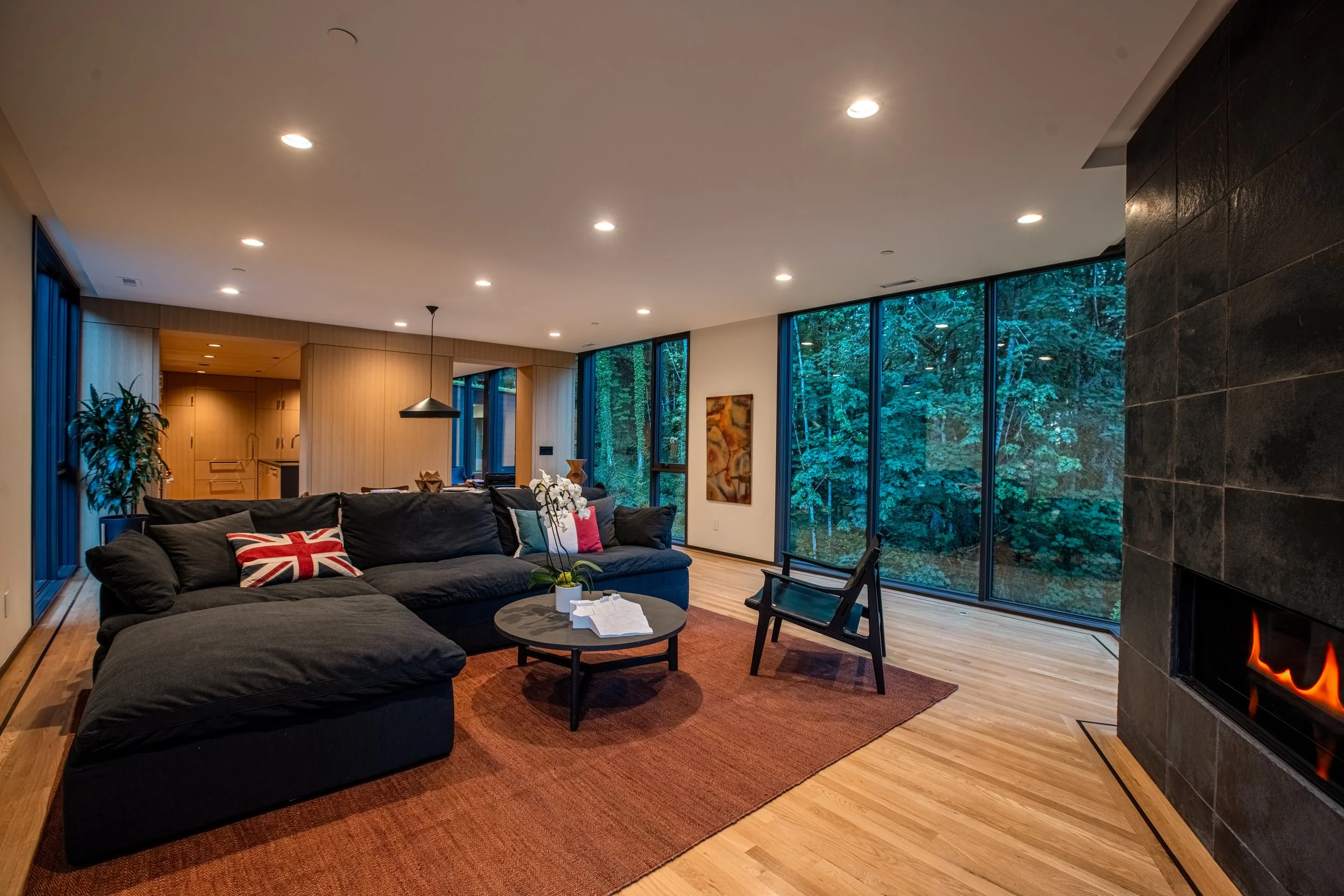 Living room with dark sectional couch and fireplace — William Kaven Architecture