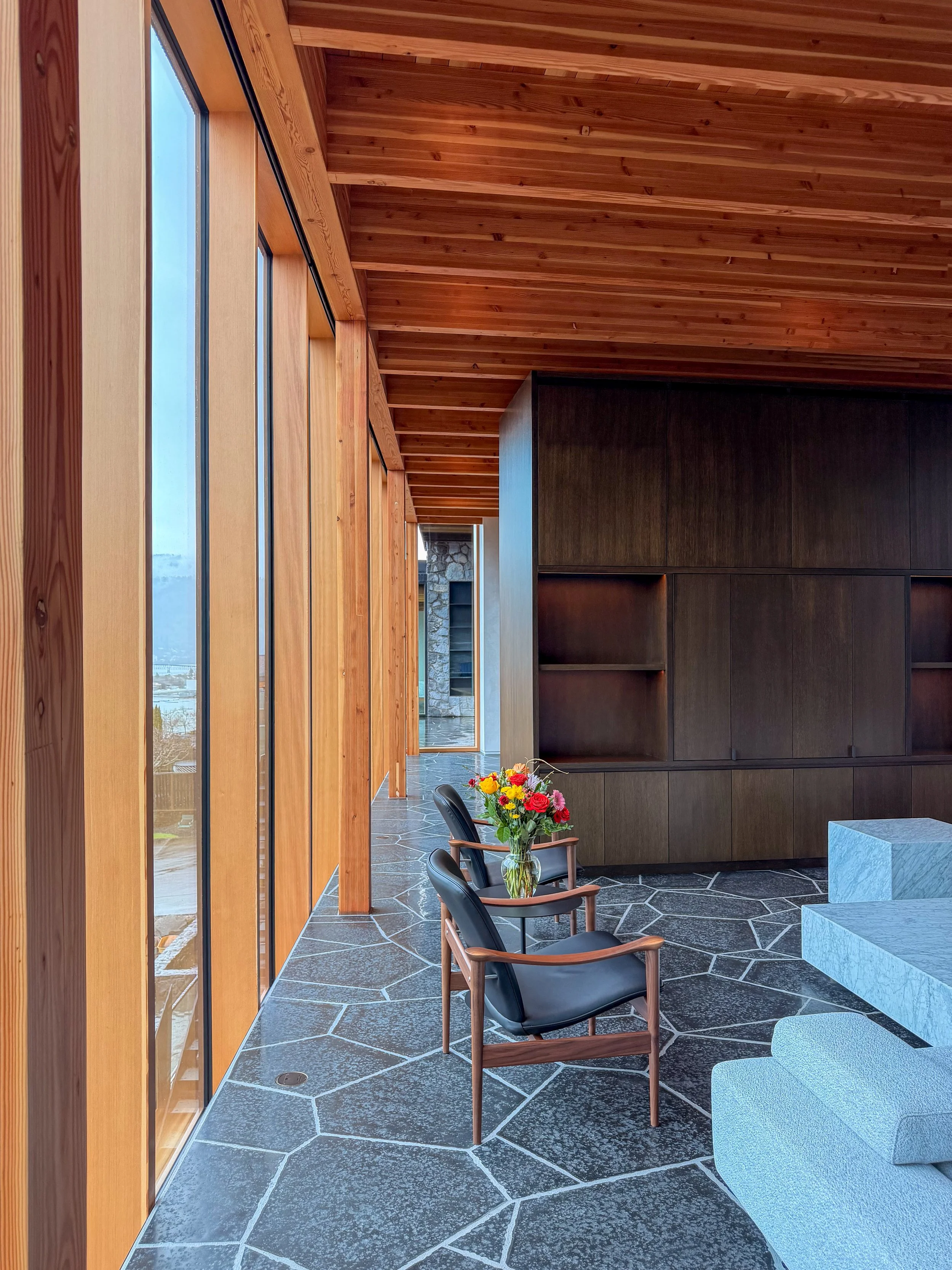 living-room-with-two-chairs-and-flower-arrangement-at-modern-hood-river-house-william-kaven-architecture