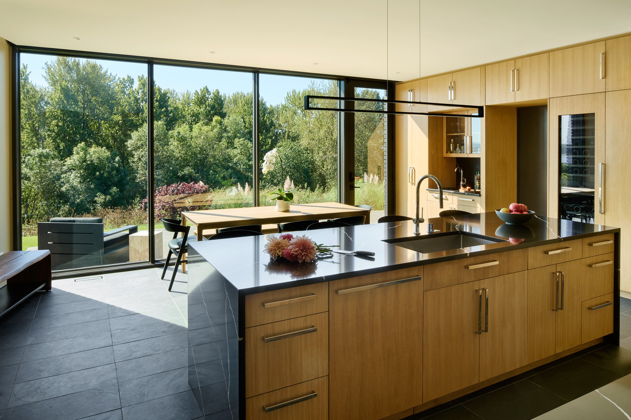 Modern kitchen with large windows and white oak cabinetry — William Kaven Architecture.