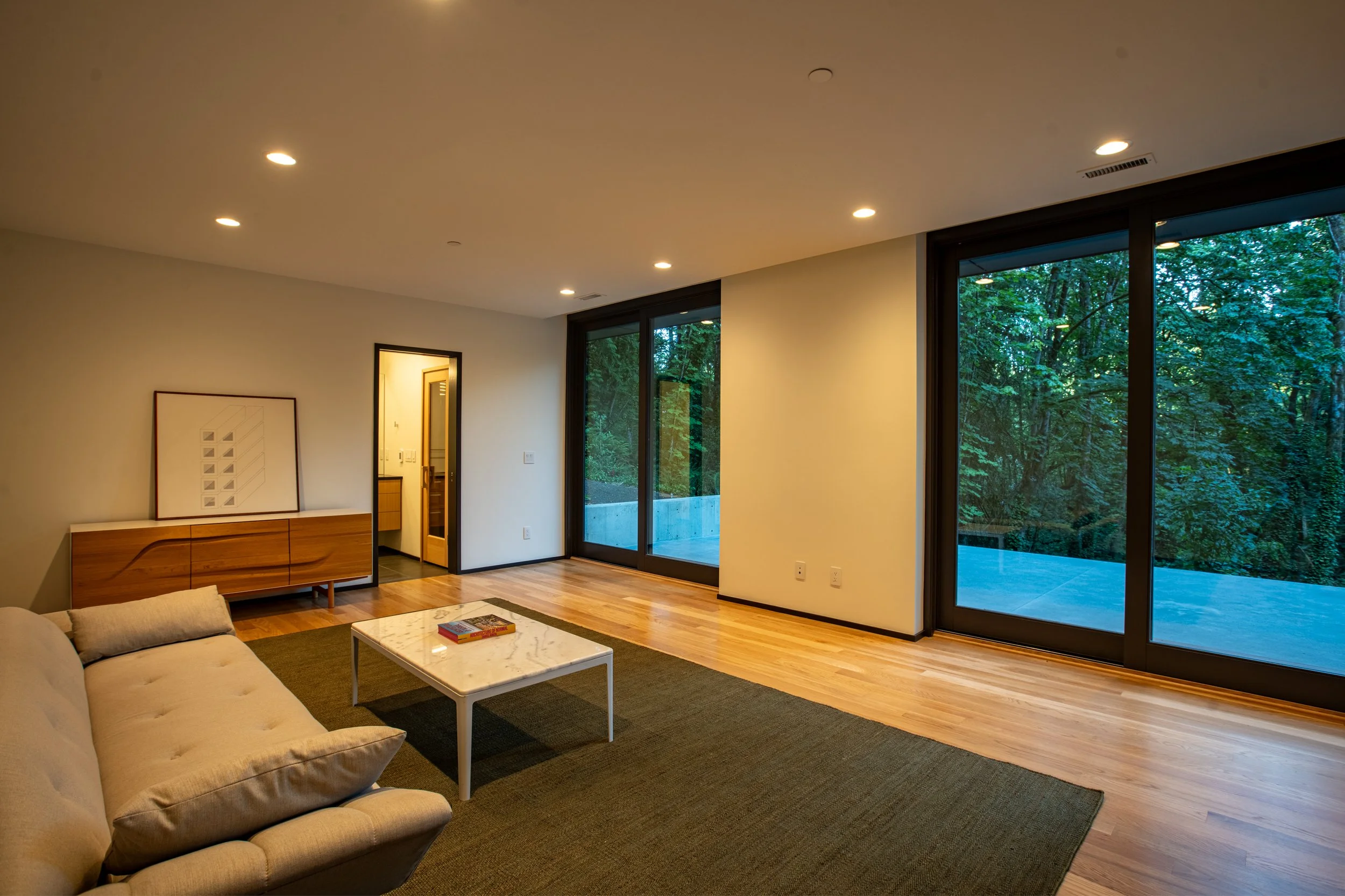Basement den with view of forest — William Kaven Architecture