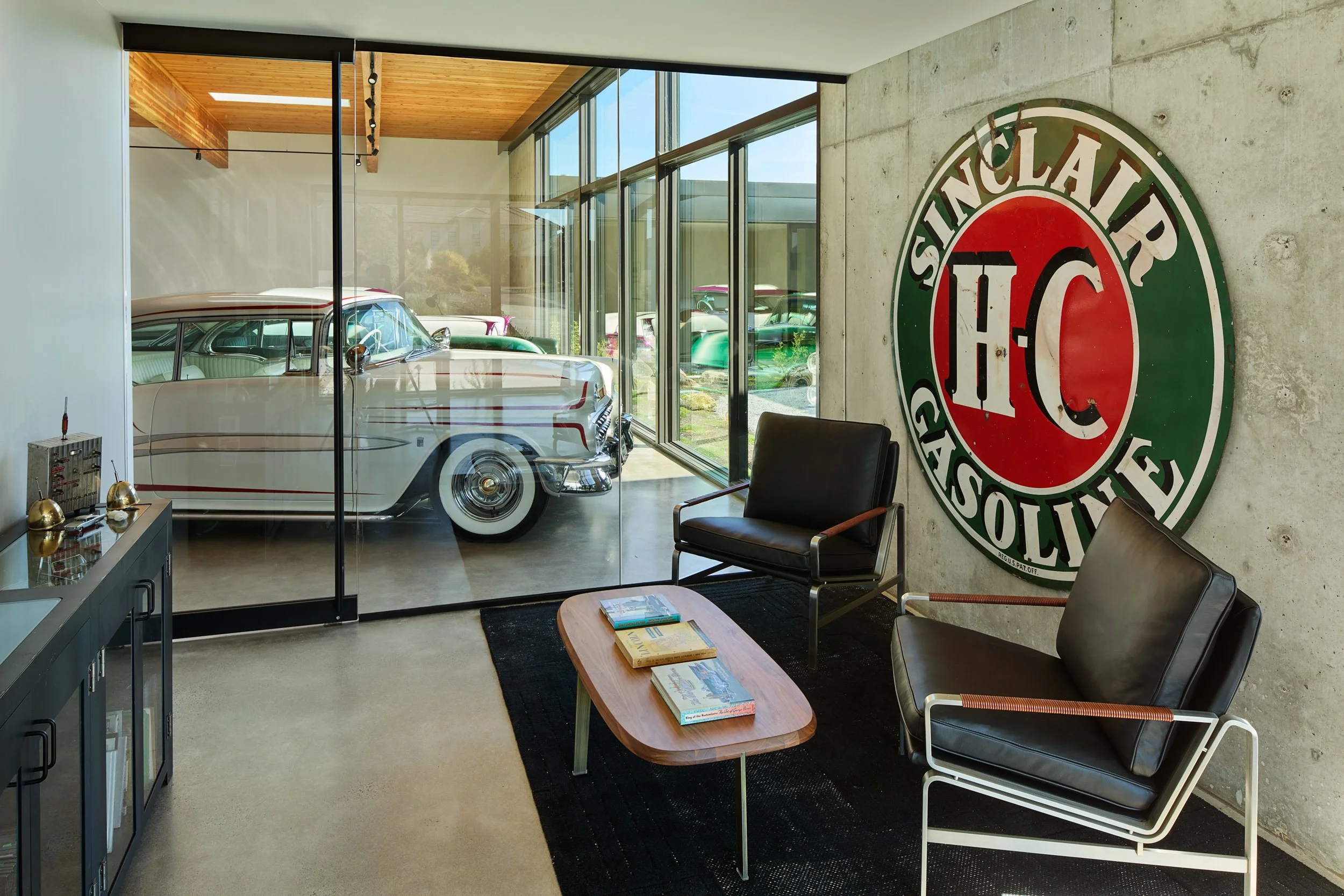 Garage office with vintage Sinclair sign and view into car gallery Car gallery with custom classic cars and view of courtyard — El Capitola residence by William Kaven Architecture
