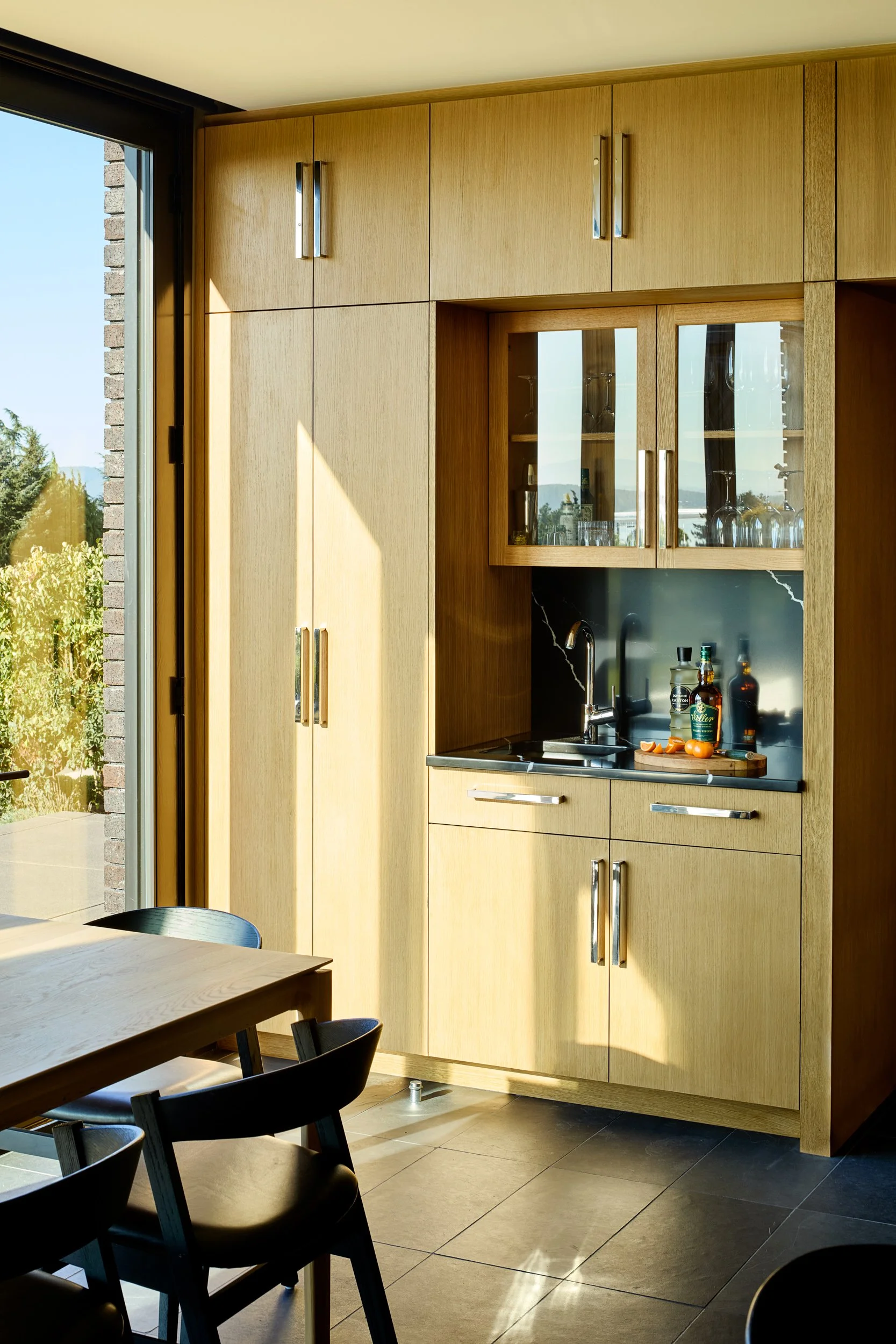 Residential wet bar with glass cabinetry — William Kaven Architecture.