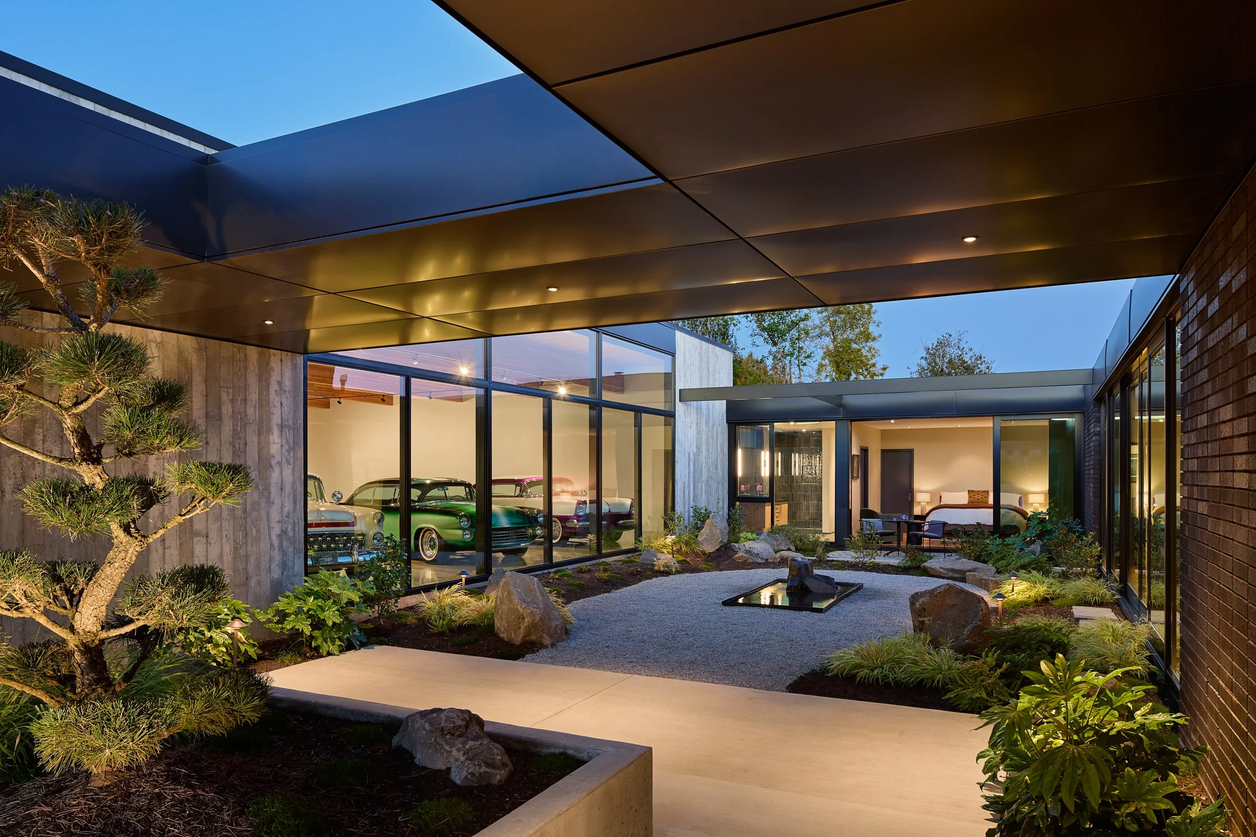 Residential courtyard designed by Red Ferrari under carport at El Capitola Residence, designed by William Kaven Architecture with view of car gallery.
